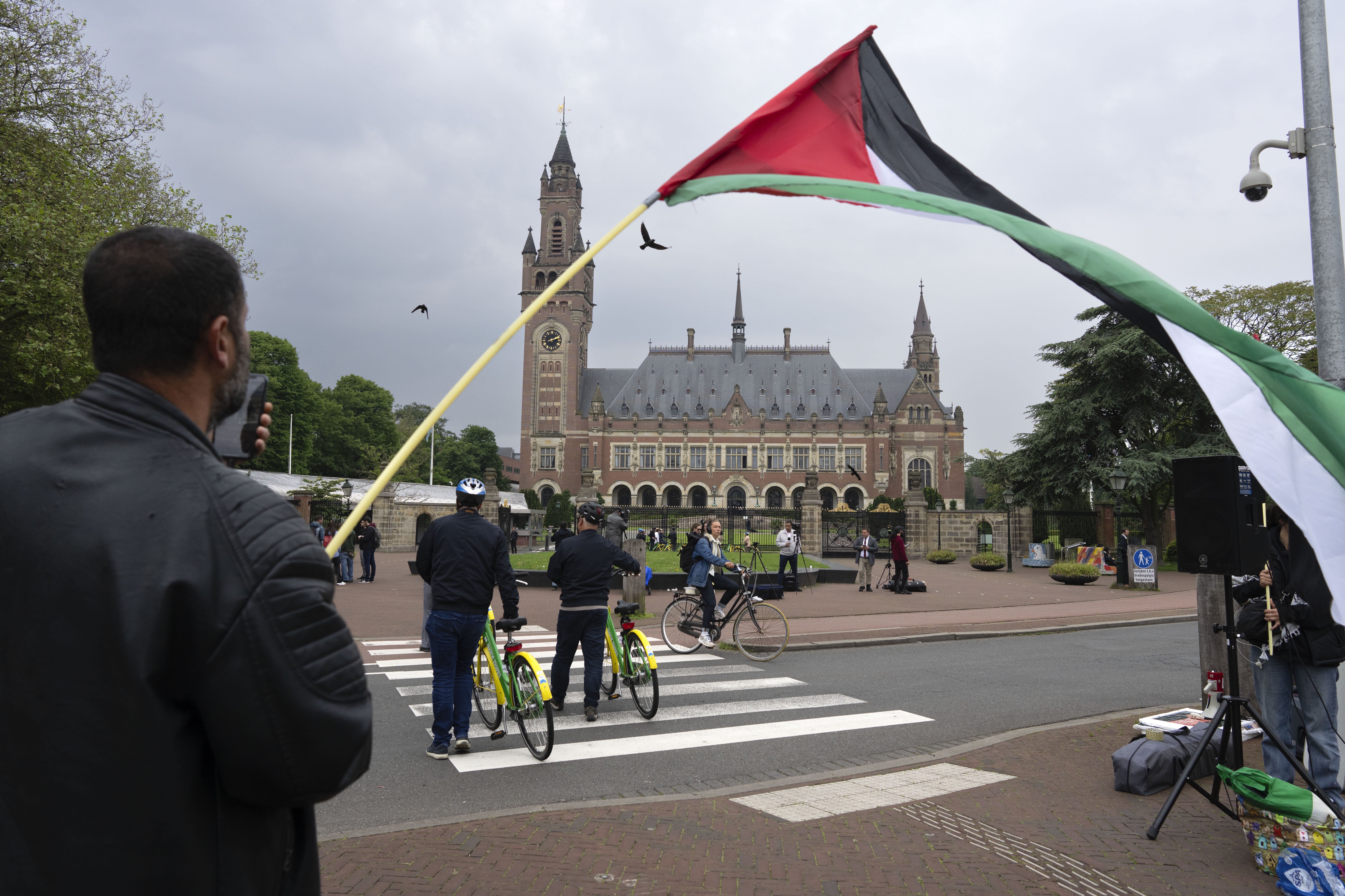 A lone demonstrator waves the Palestinian flag outside the Peace Palace, rear, housing the International Court of Justice. Photo / AP