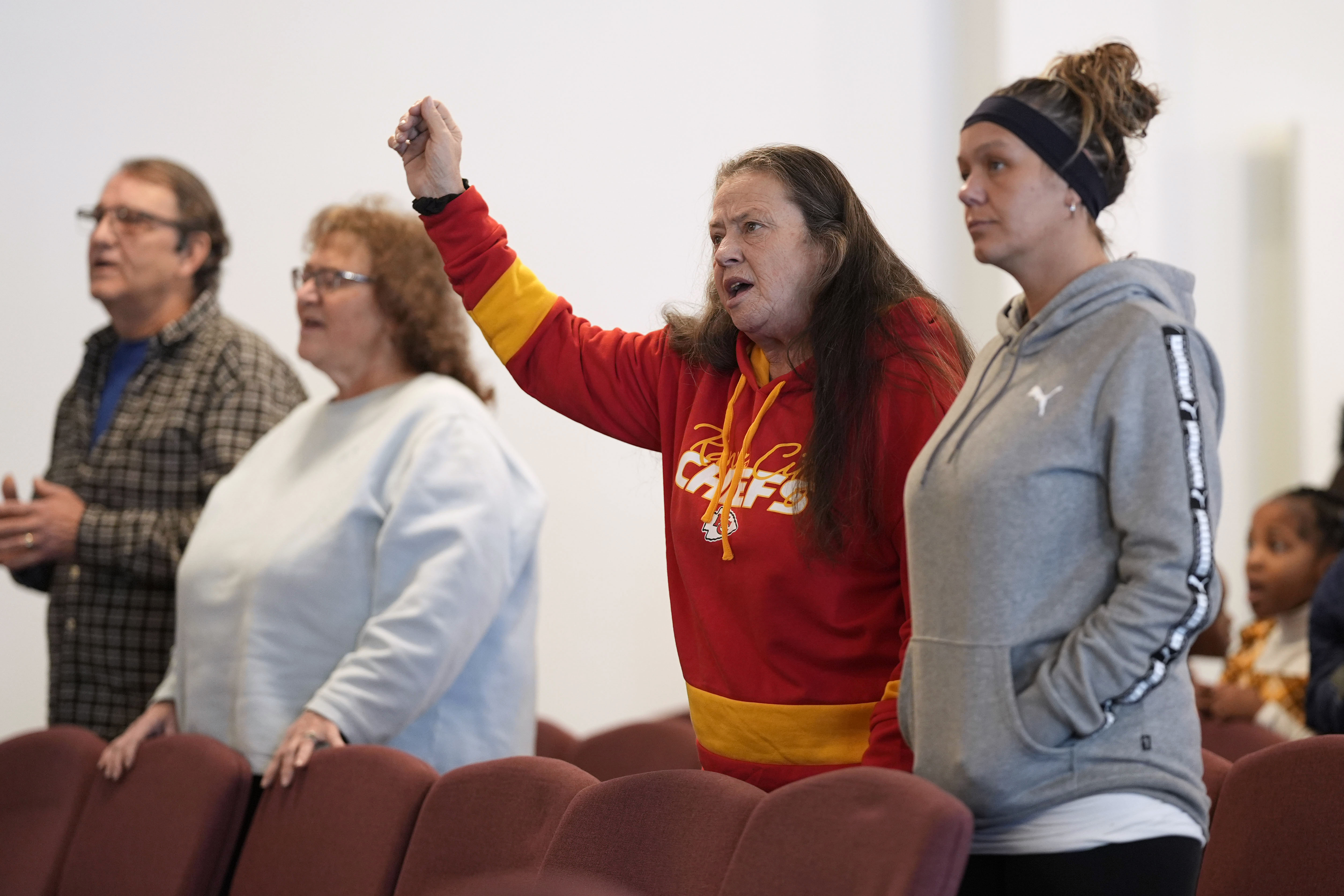 Ramona Brandt, of Des Moines, Iowa, second from right, prays during service. Photo / AP