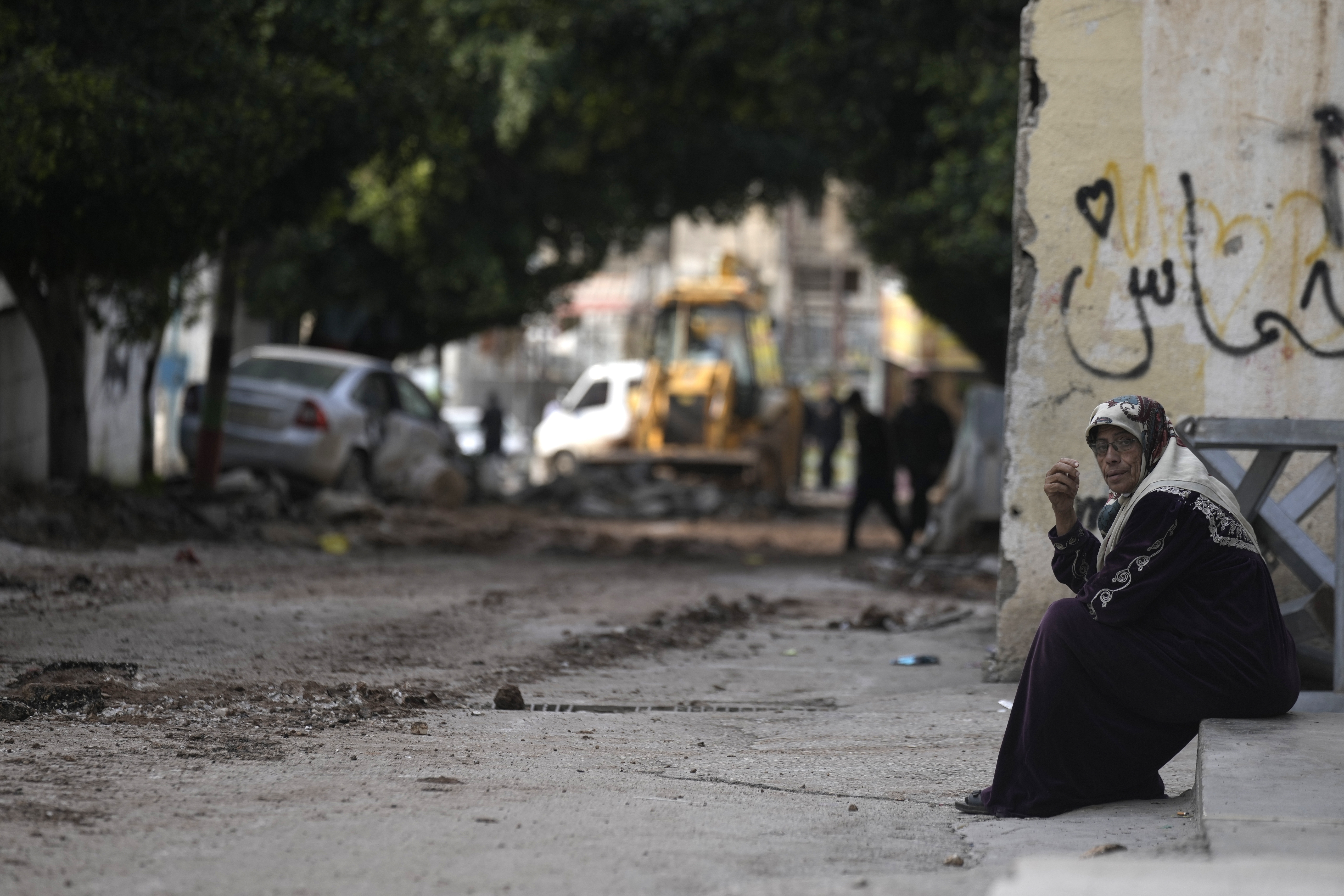 A woman sits near the site where three Palestinians were killed by Israeli fire in Faraa refugee camp near the West Bank town of Tubas. Photo / AP