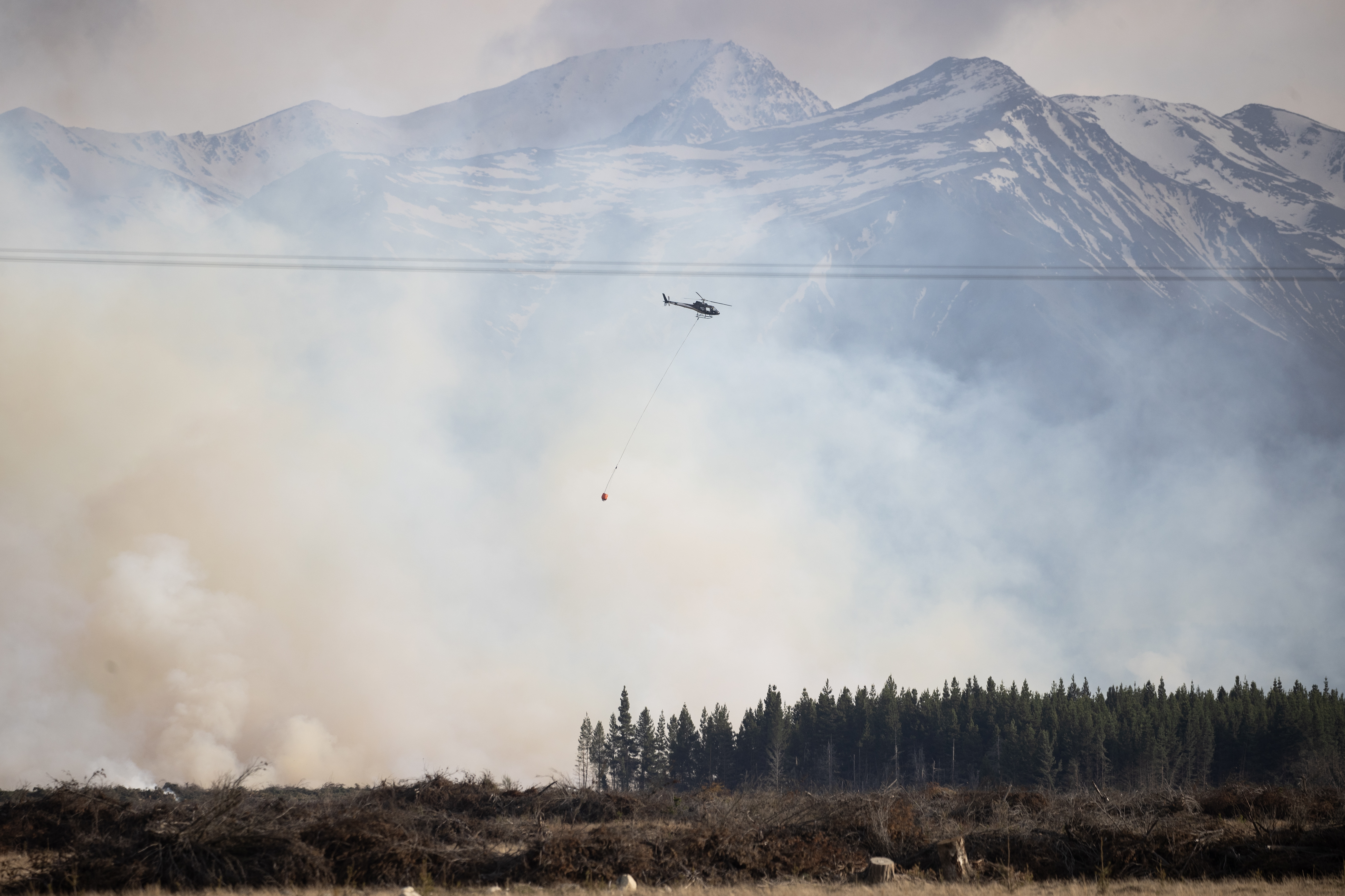Helicopters with monsoon buckets fought the fire from the skies yesterday. Photo / George Heard