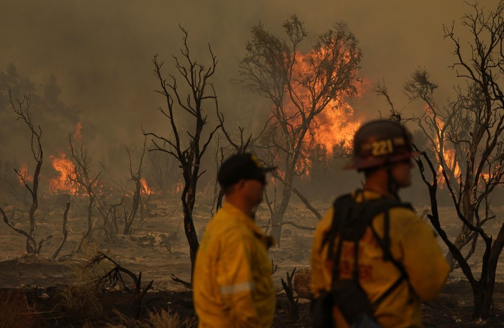 Members of the San Bernardino County Fire Department keep an eye on a flareup from the Bobcat Fire. Photo / AP