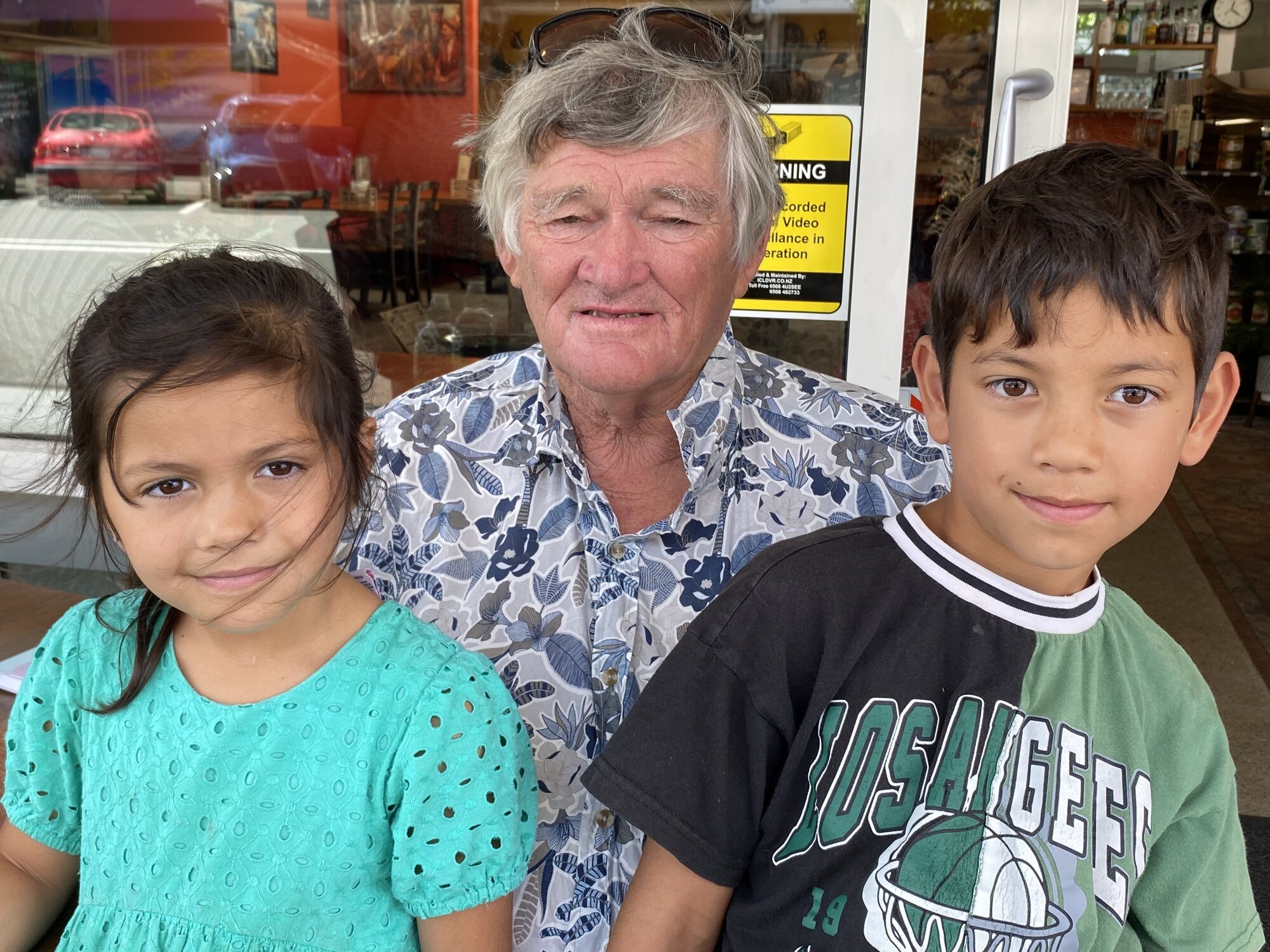  Ōakura's flood-weary Bruce Williams with his grandchildren Ayla and Reed Hetaraka. Photo / Susan Botting 
