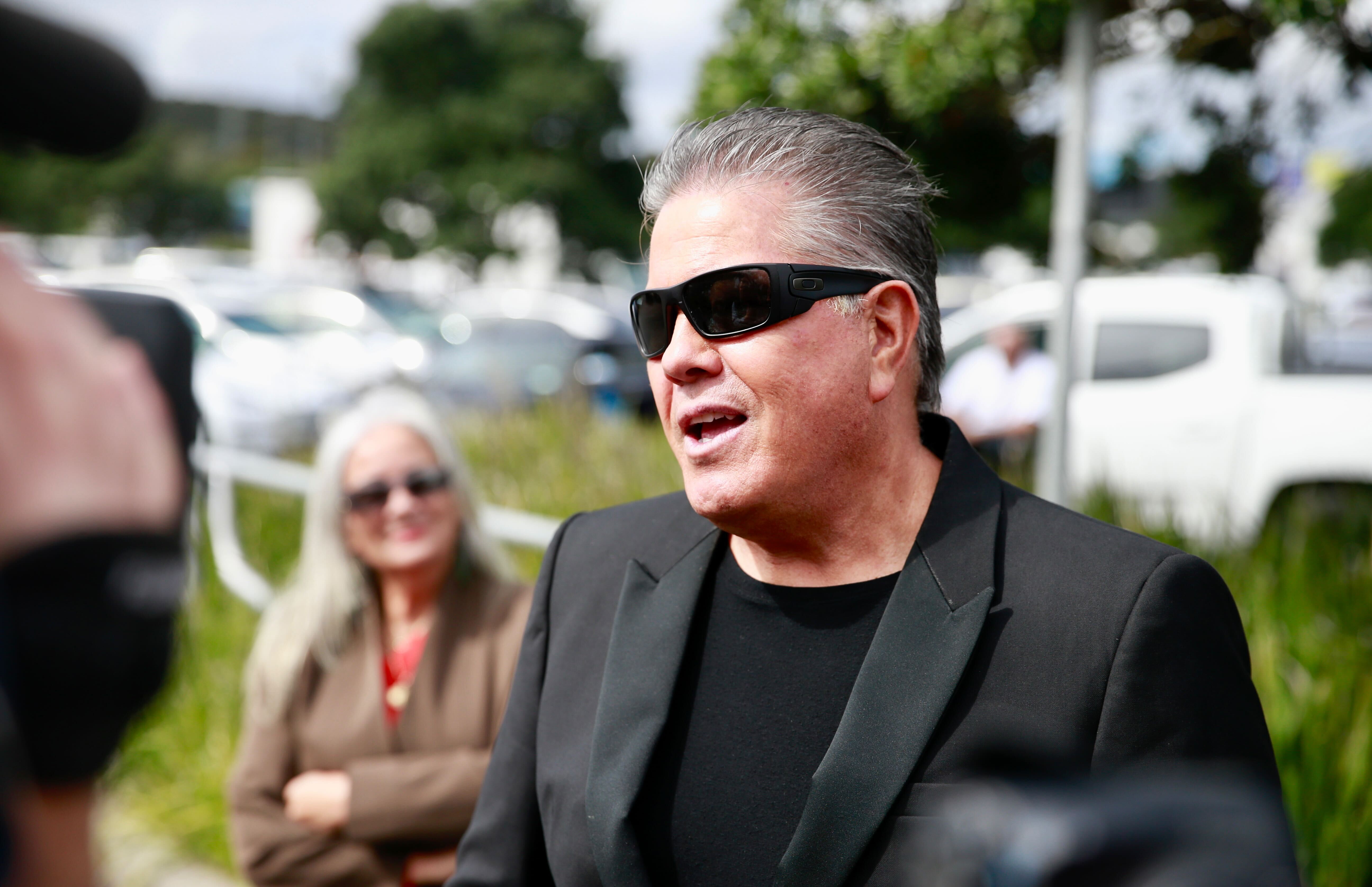 Brian Tamaki, flanked by wife Hannah,  speaks to media outside the venue for National's election campaign launch in Wiri. Photo / Alex Burton