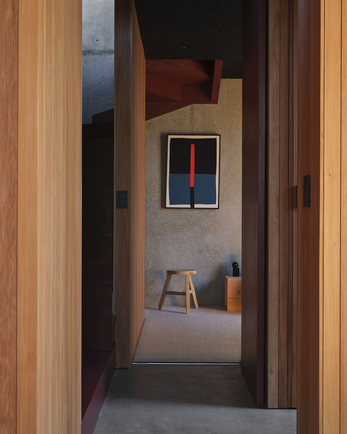 A view down the hallway with the striking red staircase to the left. Photo / Sam Hartnett