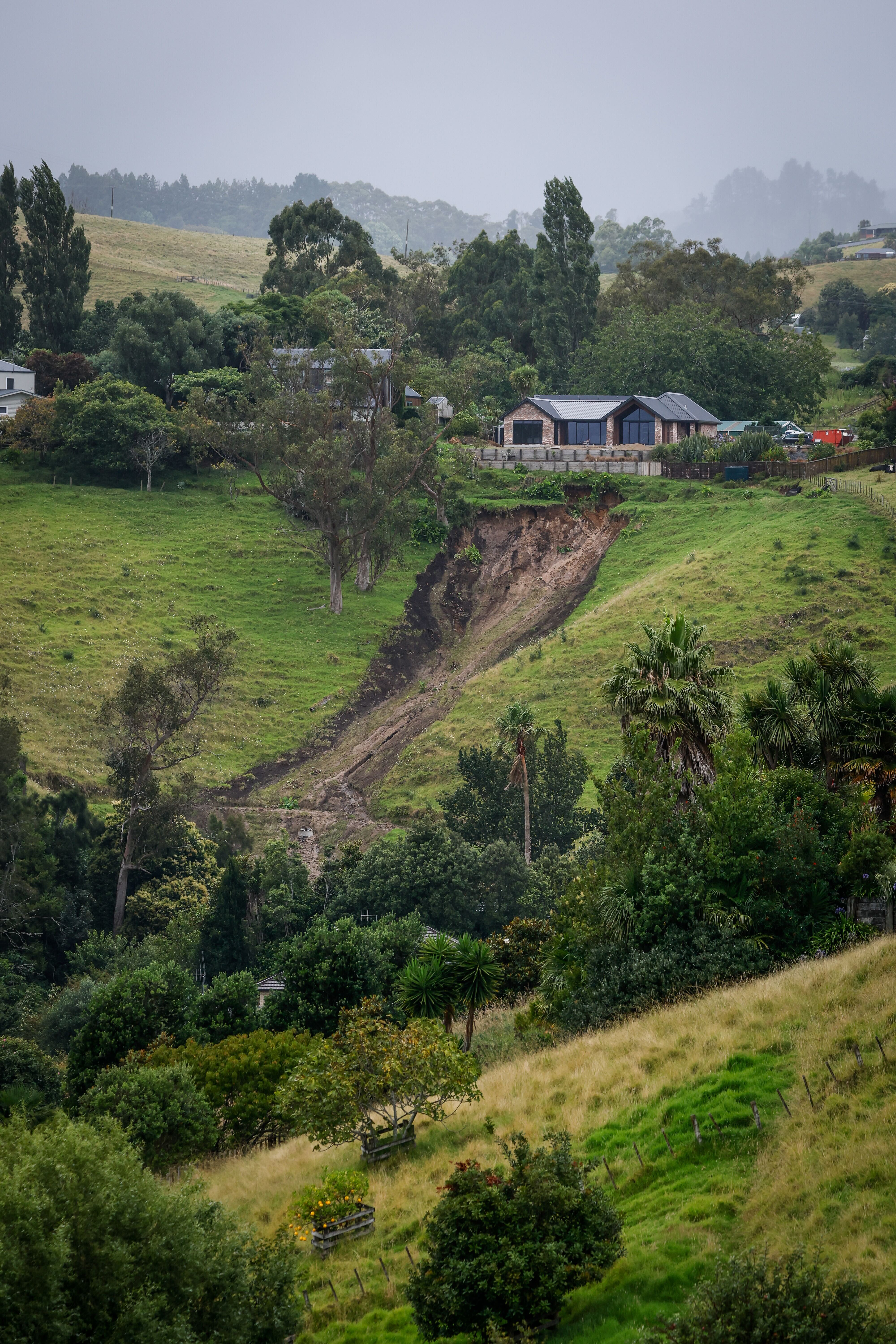 A slip has narrowly missed a new build home in the Tauranga suburb of Welcome Bay, viewed from Te Auhi Reserve on January 24, 2026. NZ Herald photo by Michael Craig