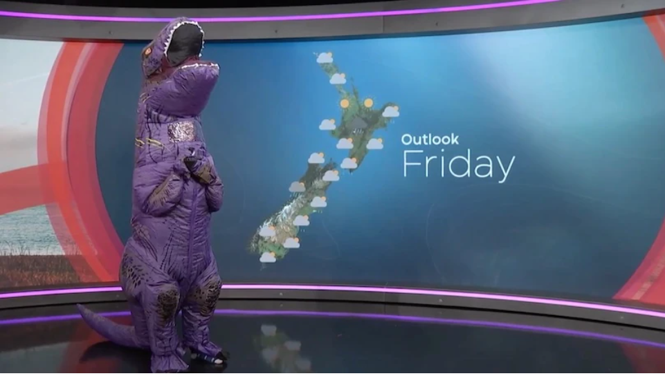 Mclean gives the weather forecast from inside an inflatable dinosaur costume. Photo / The Spinoff