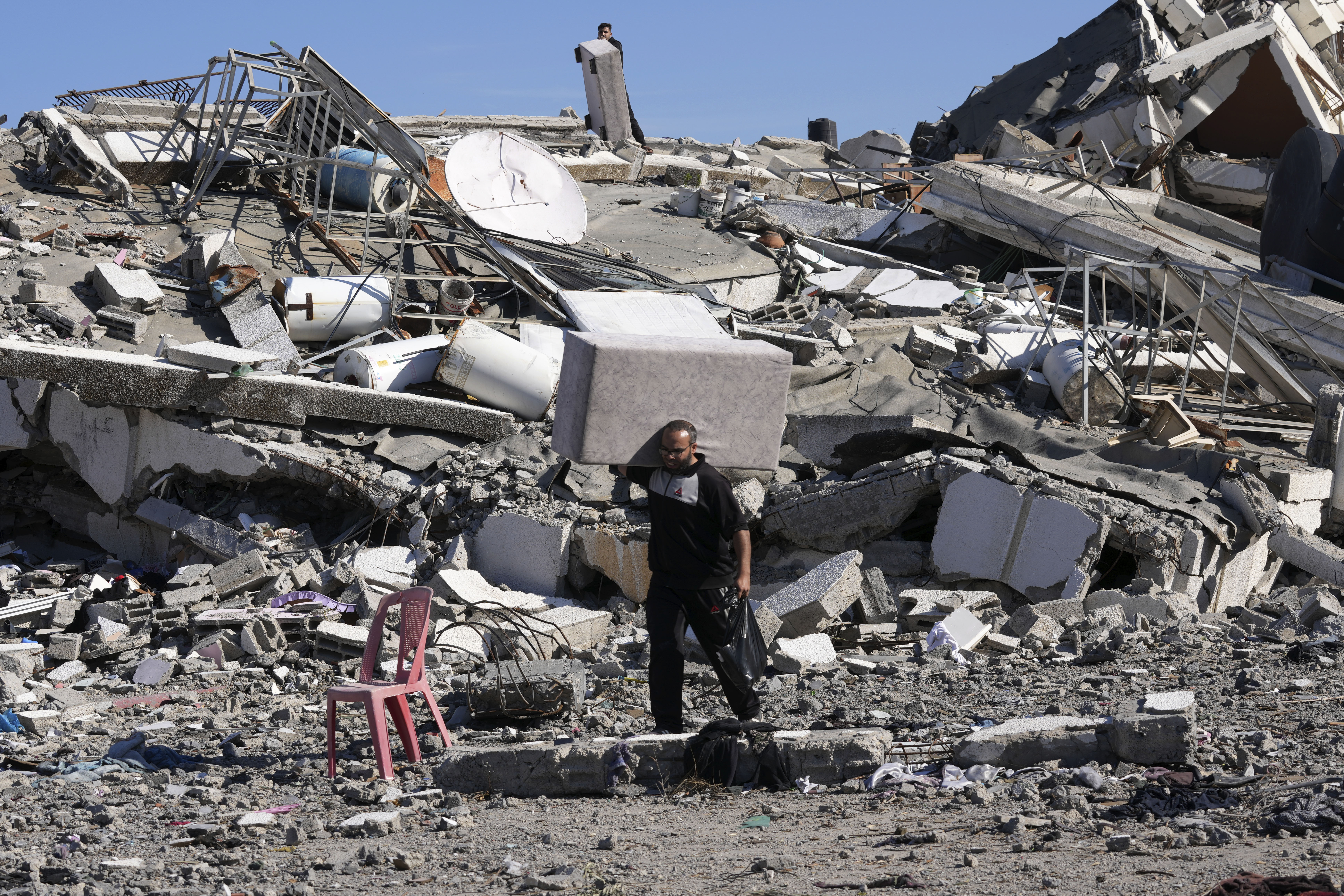 A Palestinian resident retrieves belongings in Al-Zahra on the outskirts of Gaza City during the temporary ceasefire between Hamas and Israel. Photo / AP