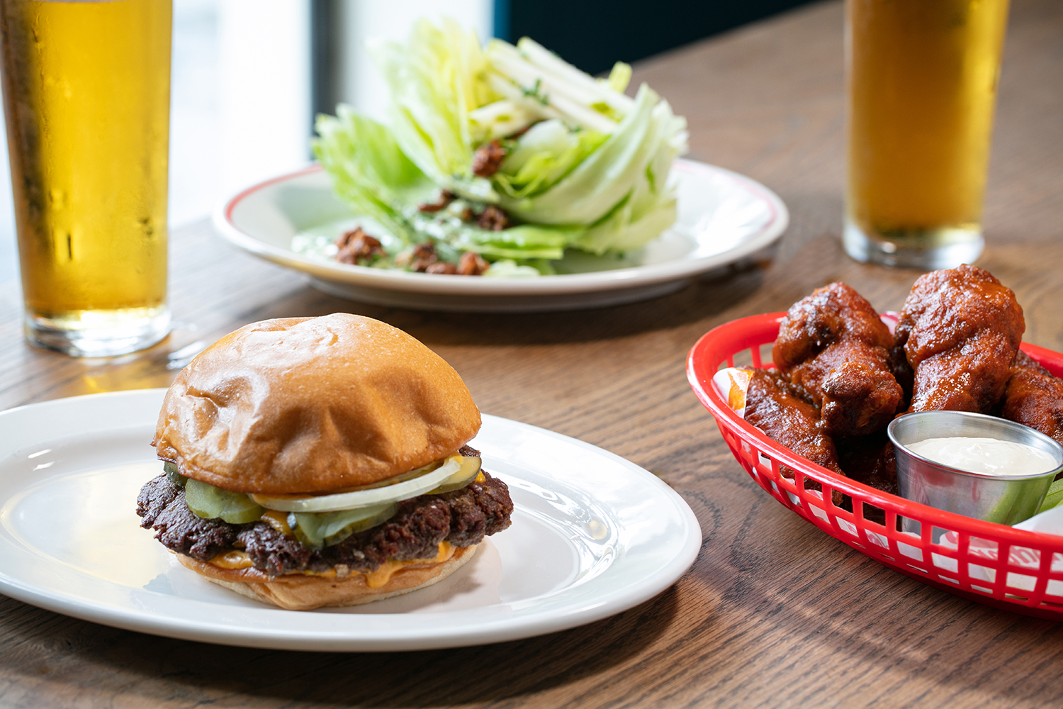 The cheese burger, gochujang chicken wings and iceberg salad. Photo / Babiche Martens