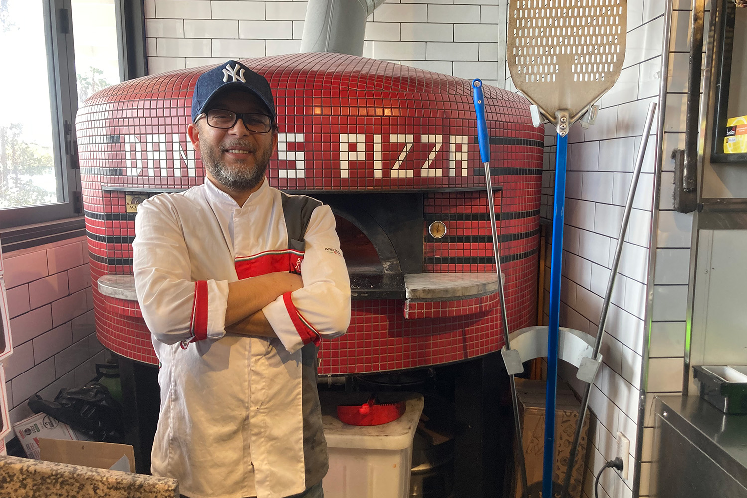 Dante's chef Enis Bacova stands in front of the pizza oven, which turns out sourdough pies of world-class quality. Photo / Madeleine Crutchley