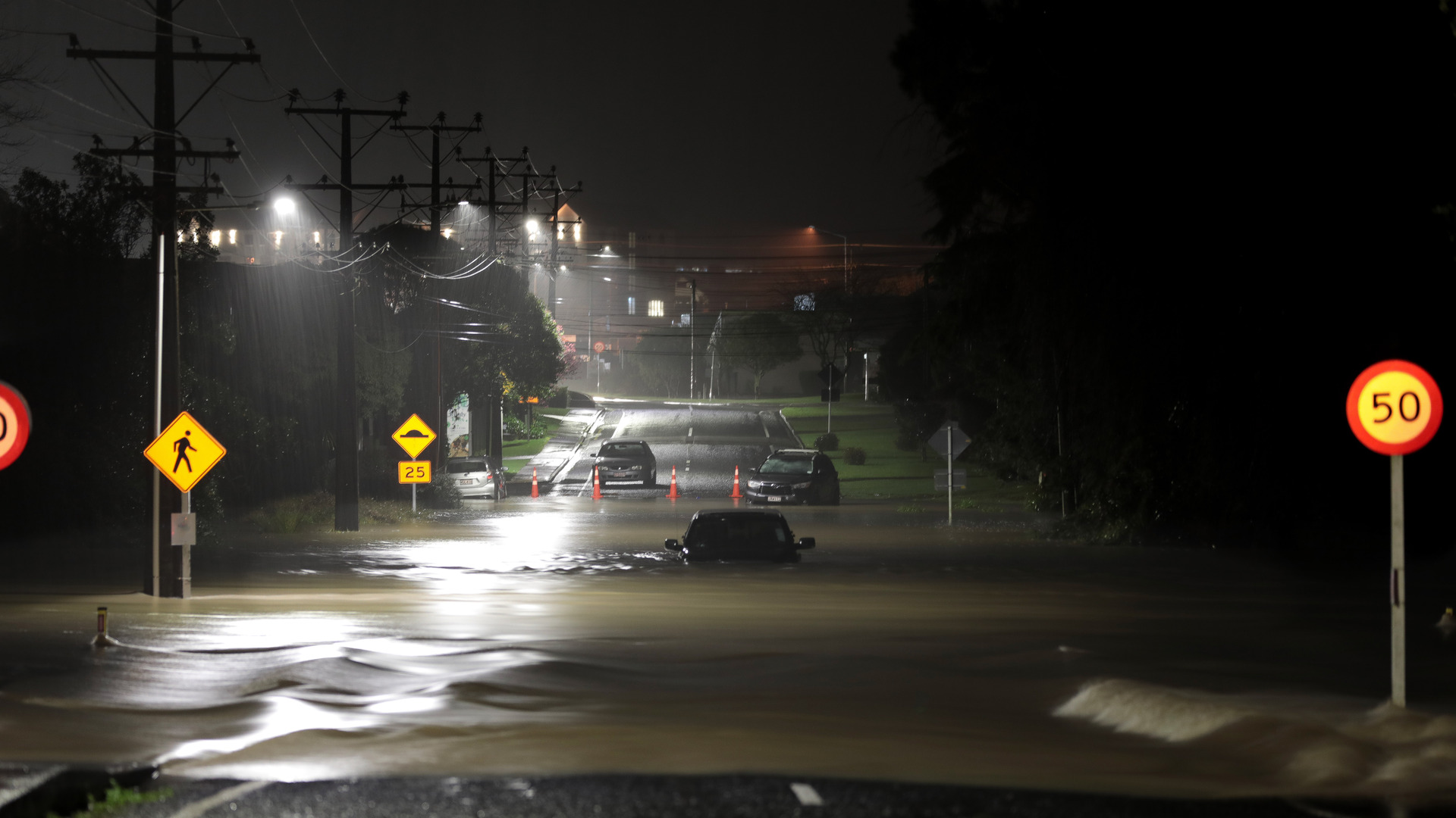 People are being rescued from cars in Kumeu after becoming trapped in floodwaters. Photo / Hayden Woodward