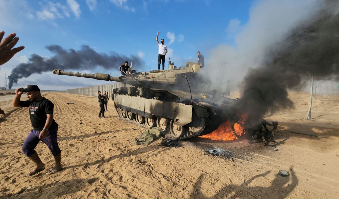 Palestinians celebrate by a destroyed Israeli tank at Gaza fence east of Khan Younis. Photo / AP