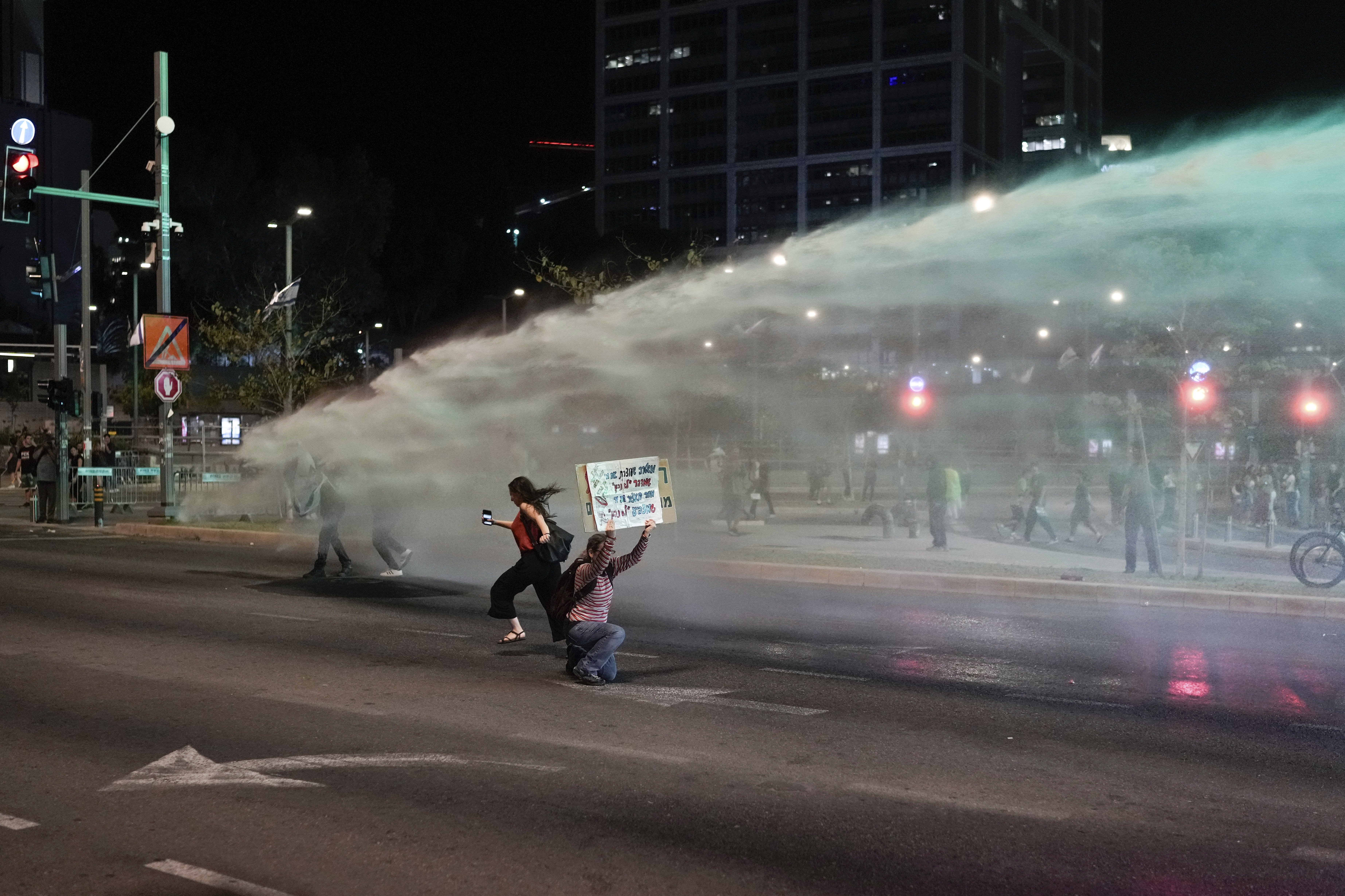 Police use a water cannon to disperse demonstrators blocking a road during a protest against Israeli Prime Minister Benjamin Netanyahu's government, and calling for the release of hostages held in the Gaza Strip by the Hamas militant group, in Tel Aviv. Photo / AP
