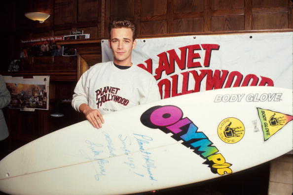 Actor Luke Perry holding autographed surfboard at Planet Hollywood. Photo / Getty