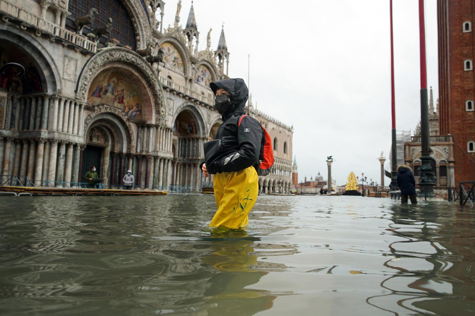 People wade their way through the water in flooded St. Mark's Square following a high tide, in December 2020. Photo / Anteo Marinoni, AP Photo