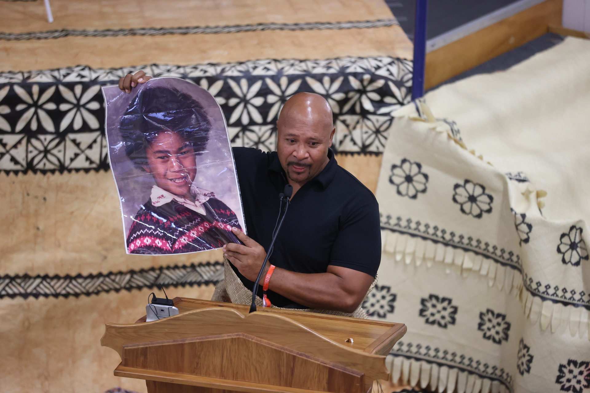 Childhood friend Afi Leuila holds a photo of a young Va'aiga 