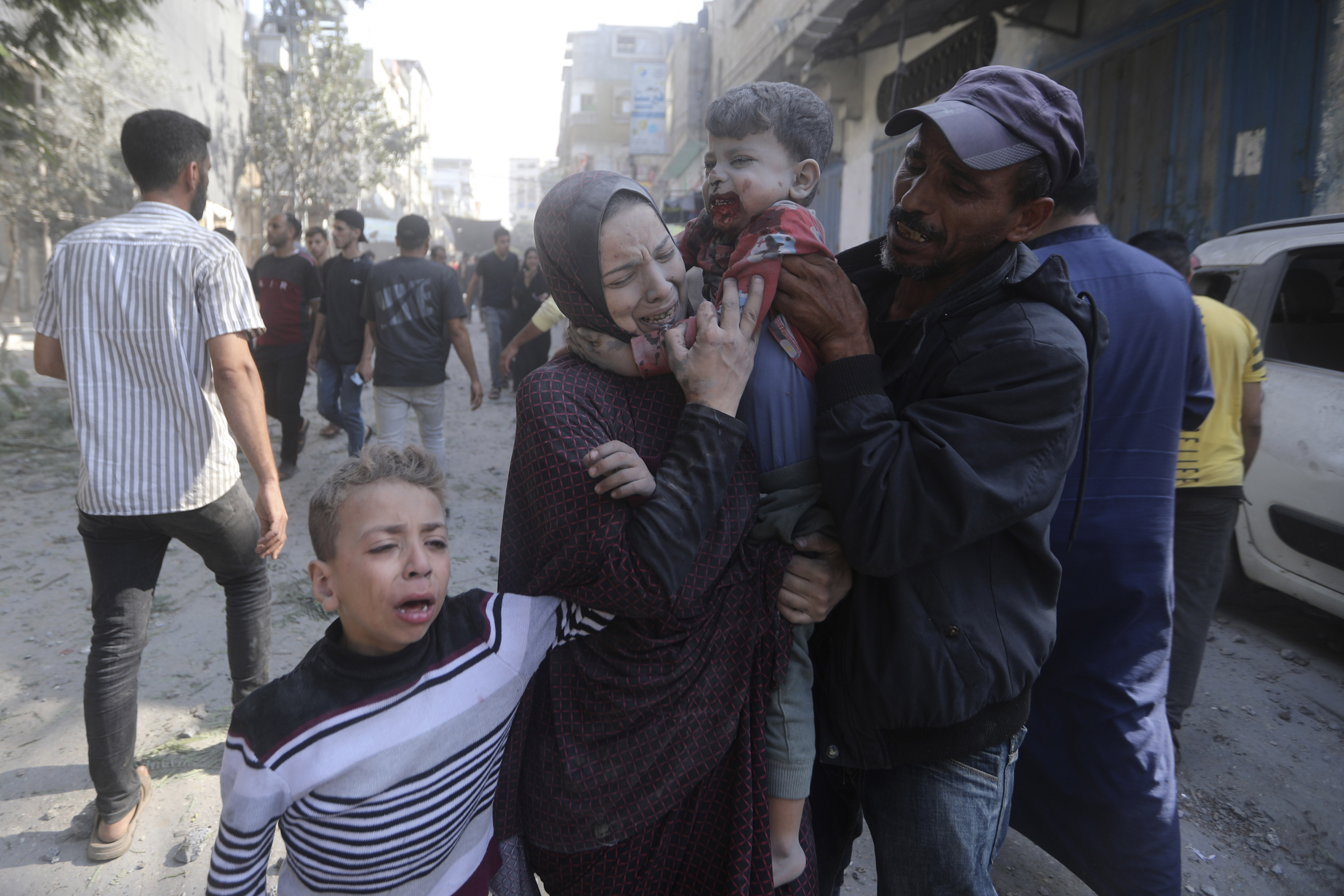 A Palestinian woman cries as she carries her wounded son following an Israeli airstrike in Bureij refugee camp, Gaza Strip, on Thursday. Photo / AP 
