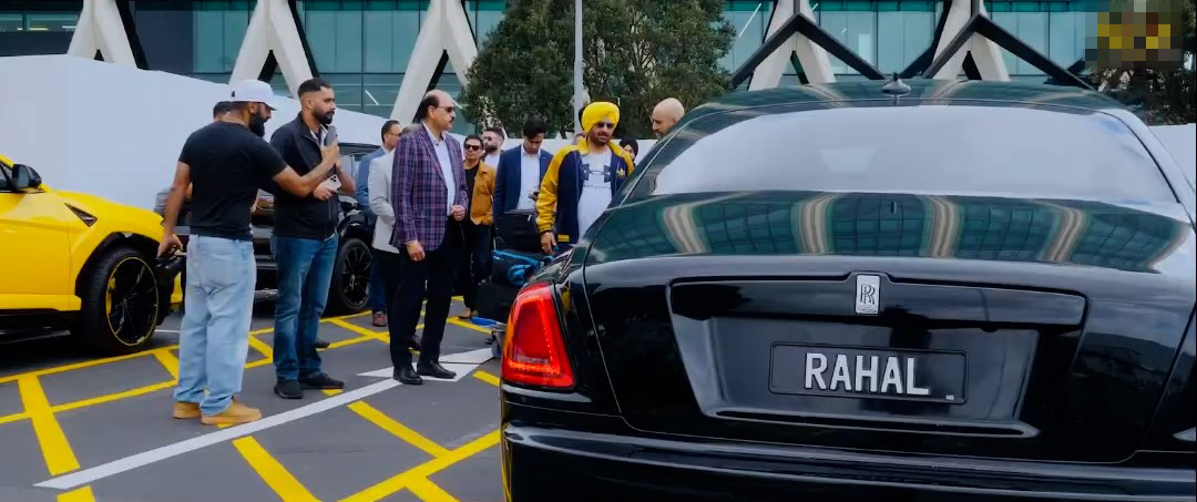 Indian singing star Malkit Singh (wearing a yellow turban) is picked up by Davinder Rahal's Rolls-Royce Ghost after he arrived in New Zealand to perform in October 2023. 