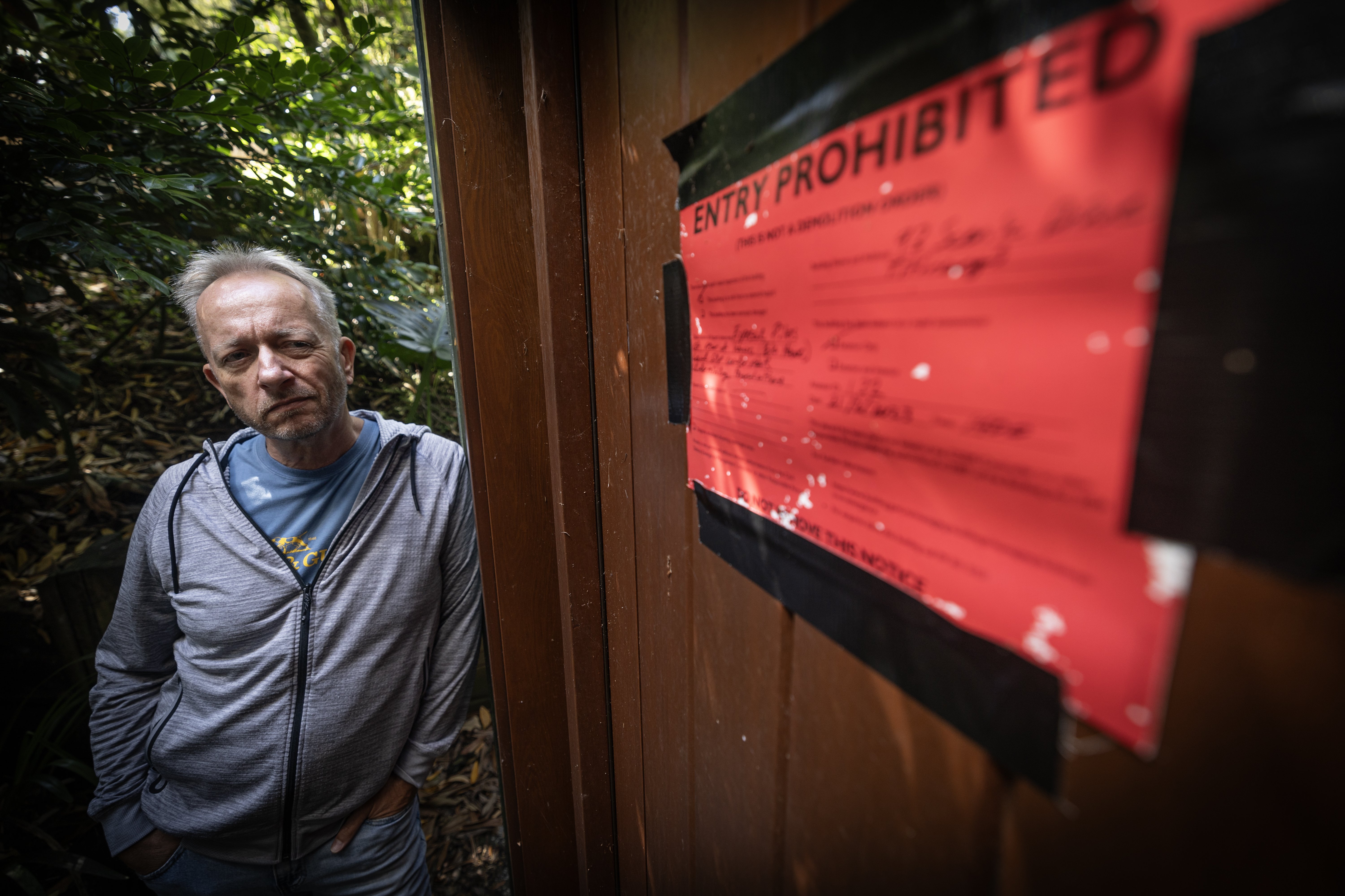 Chris Whyman has not been able to access his red-stickered Titirangi home for more than a year.  Photo /  Jason Oxenham