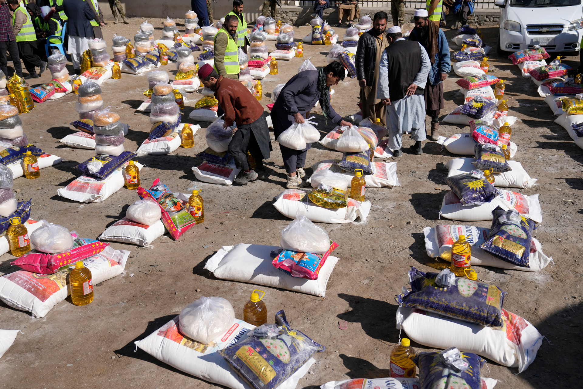 Afghan workers prepare food supplies during a humanitarian aid campaign for poor families. Photo / AP
