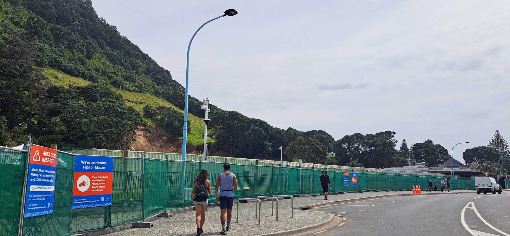 Shipping containers inside barrier fencing on Adams Ave partly obscure the view of slip-ravaged Mauao. Photo / Sandra Conchie