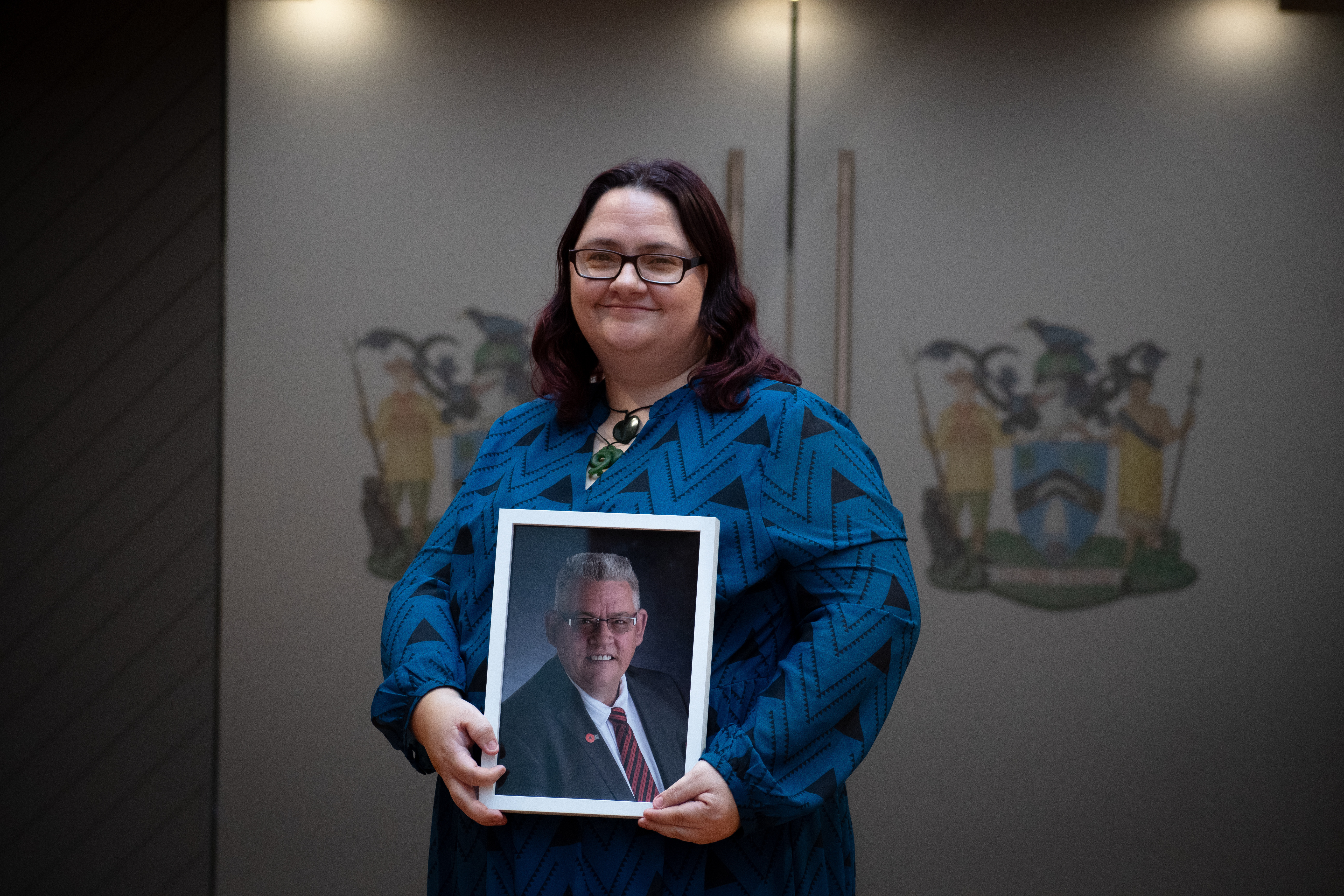 Elizabeth Sturt stands in front of Rotorua Lakes Council chambers with a picture of her late father and former councillor, Charles Sturt. Photo / Laura Smith