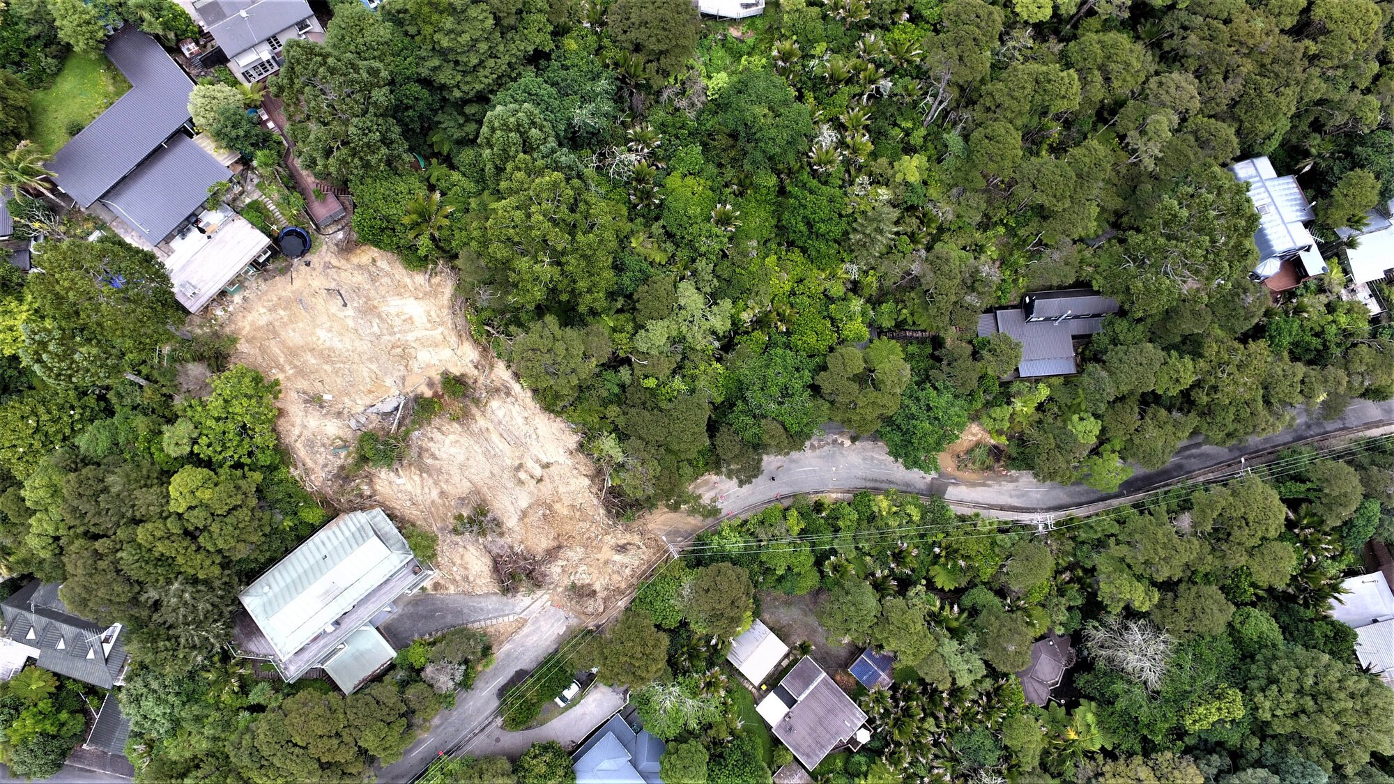 Numerous slips resulted from the Auckland Anniversary floods in 2023, including this large slide in Titirangi. Rachael Feather's home is on the right with the small slip dropping on to Wood Bay Rd. Photo / Supplied