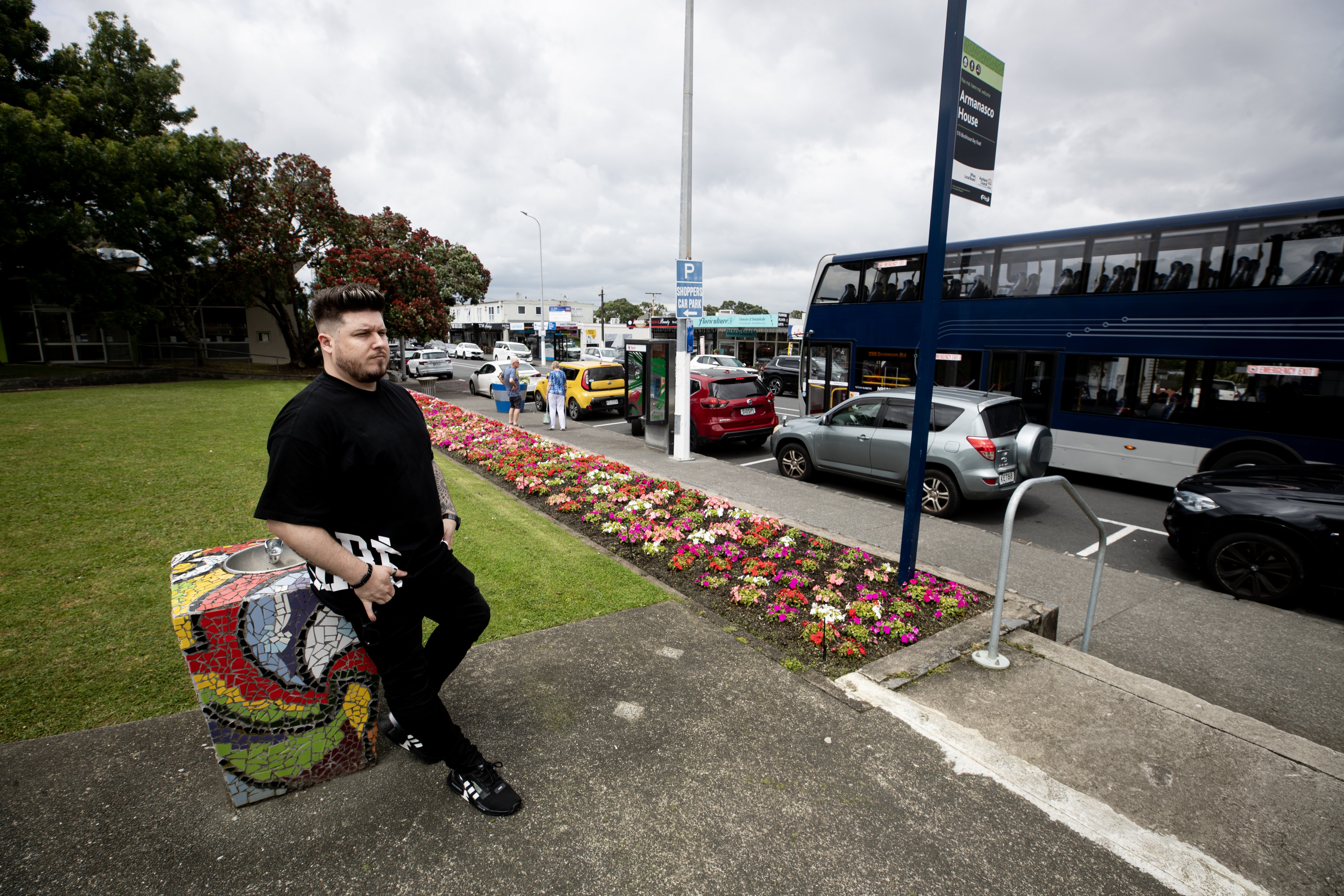 Blockhouse Bay hairdresser Matt Borsos outside the village green he says will be ruined by the planned new bus layover. Photo / Dean Purcell