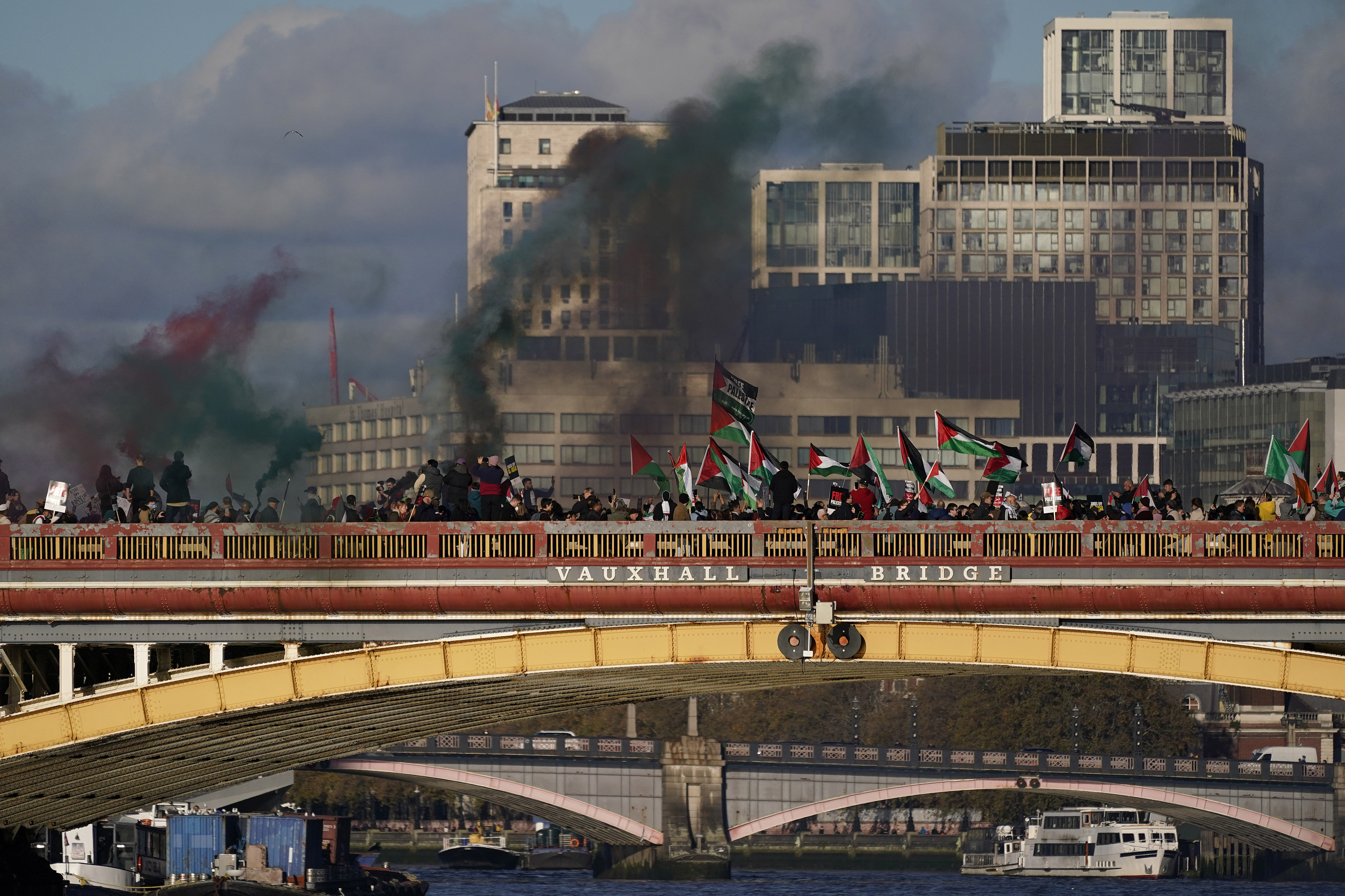 Protesters wave flags and hold flares during a pro-Palestinian protest in London. Photo / AP