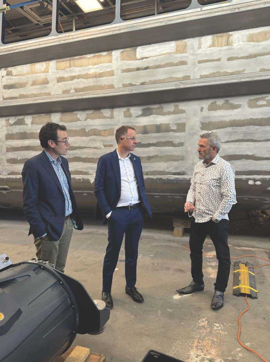 Whanganui MP Carl Bates (left) and Climate Change Minister Simon Watts (centre) with Q-West managing director Myles Fothergill looking at progress on an electric-powered ferry due for completion in 2025.
