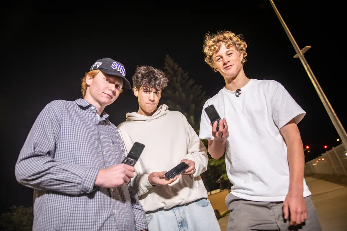 Mt Maunganui teenagers (from left) Connor Cummins, Israel Cameron and Isaac Reid use old-school phones with no internet capacity. Photo / RNZ