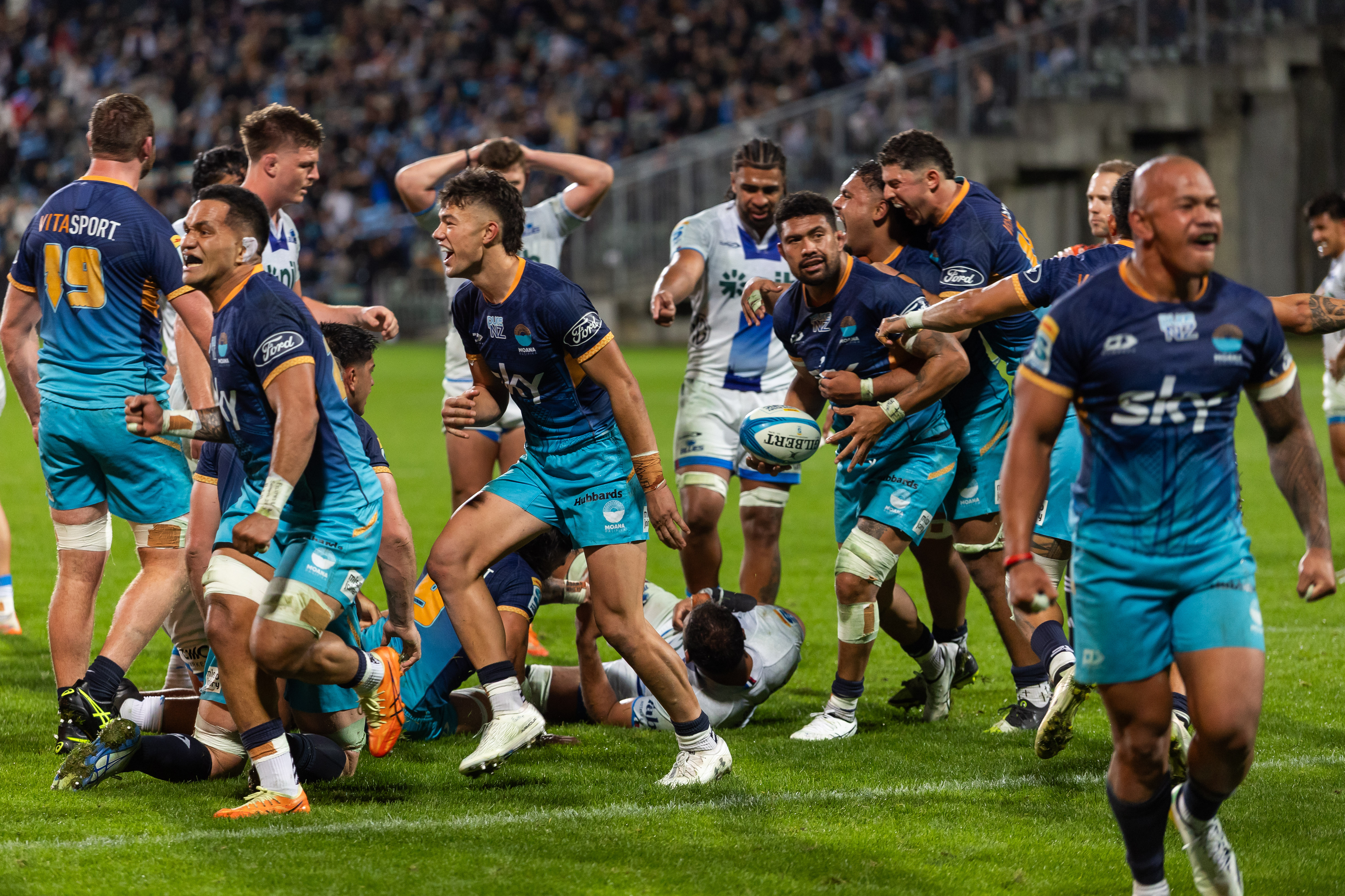 Moana Pasifika players celebrate their win over the Blues. Photo / Photosport