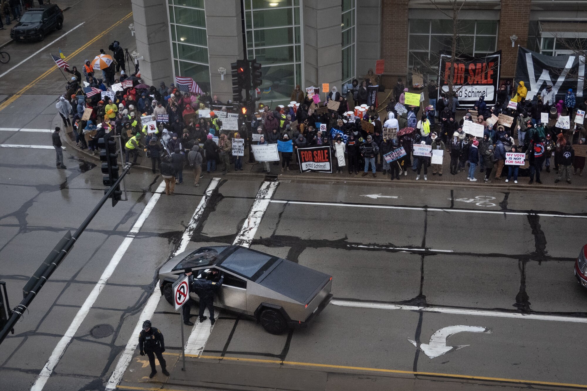 Police talk to the driver of a Tesla Cybertruck driving past demonstrators protesting outside the KI Convention Center before the start of a town hall meeting with Elon Musk on March 30, 2025 in Green Bay, Wisconsin. Photo / Getty Images