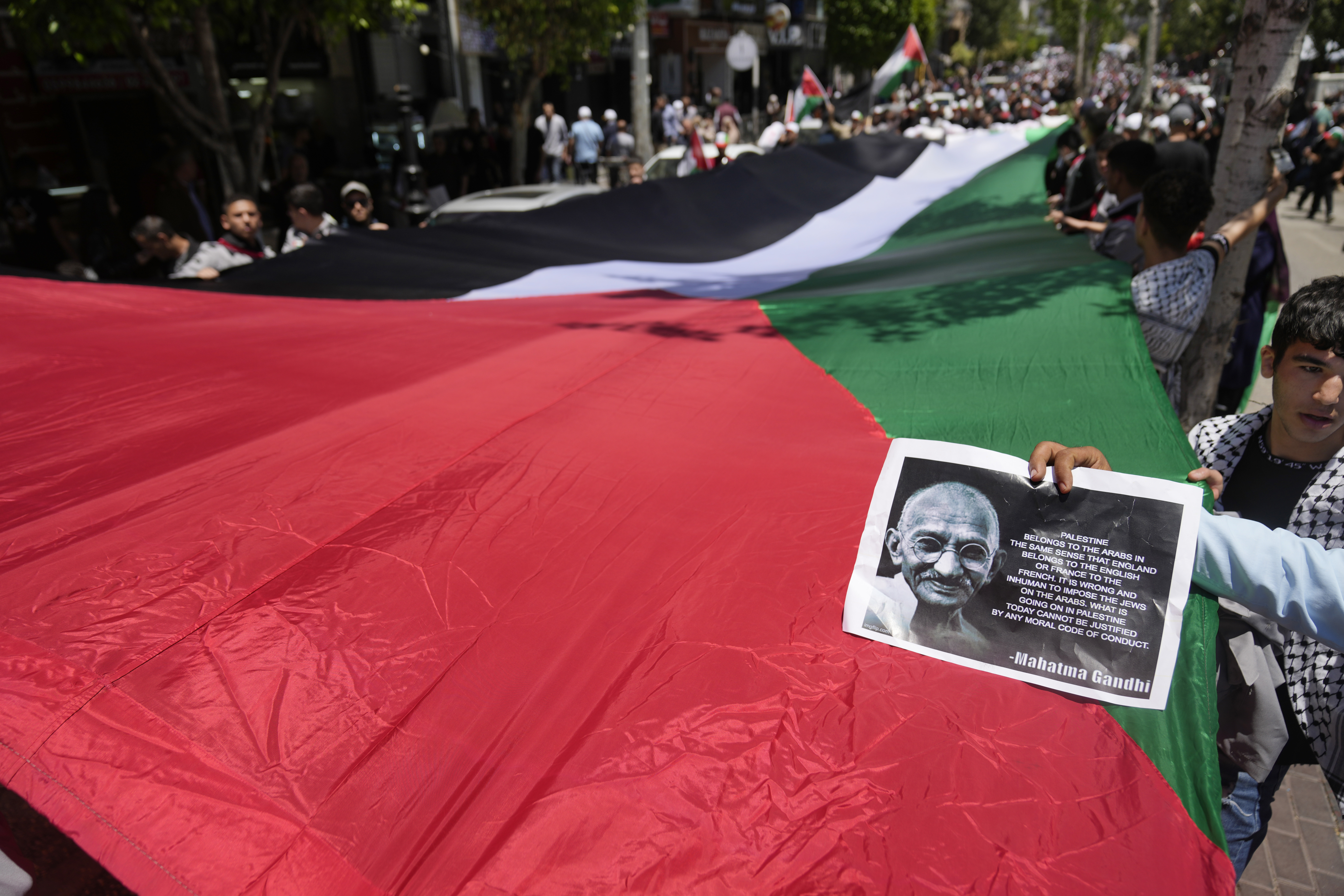 Activists carry a large Palestinian flag during a mass ceremony to commemorate the Nakba Day. Photo / AP