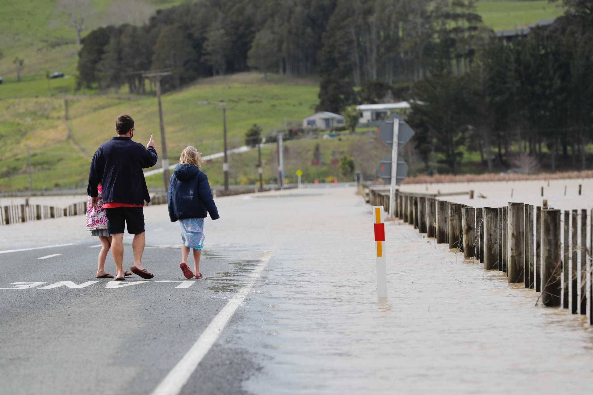 Leon England with his daughters Mckenna and Emeliya surveying the flood near Woodhill. Photo / Dean Purcell 