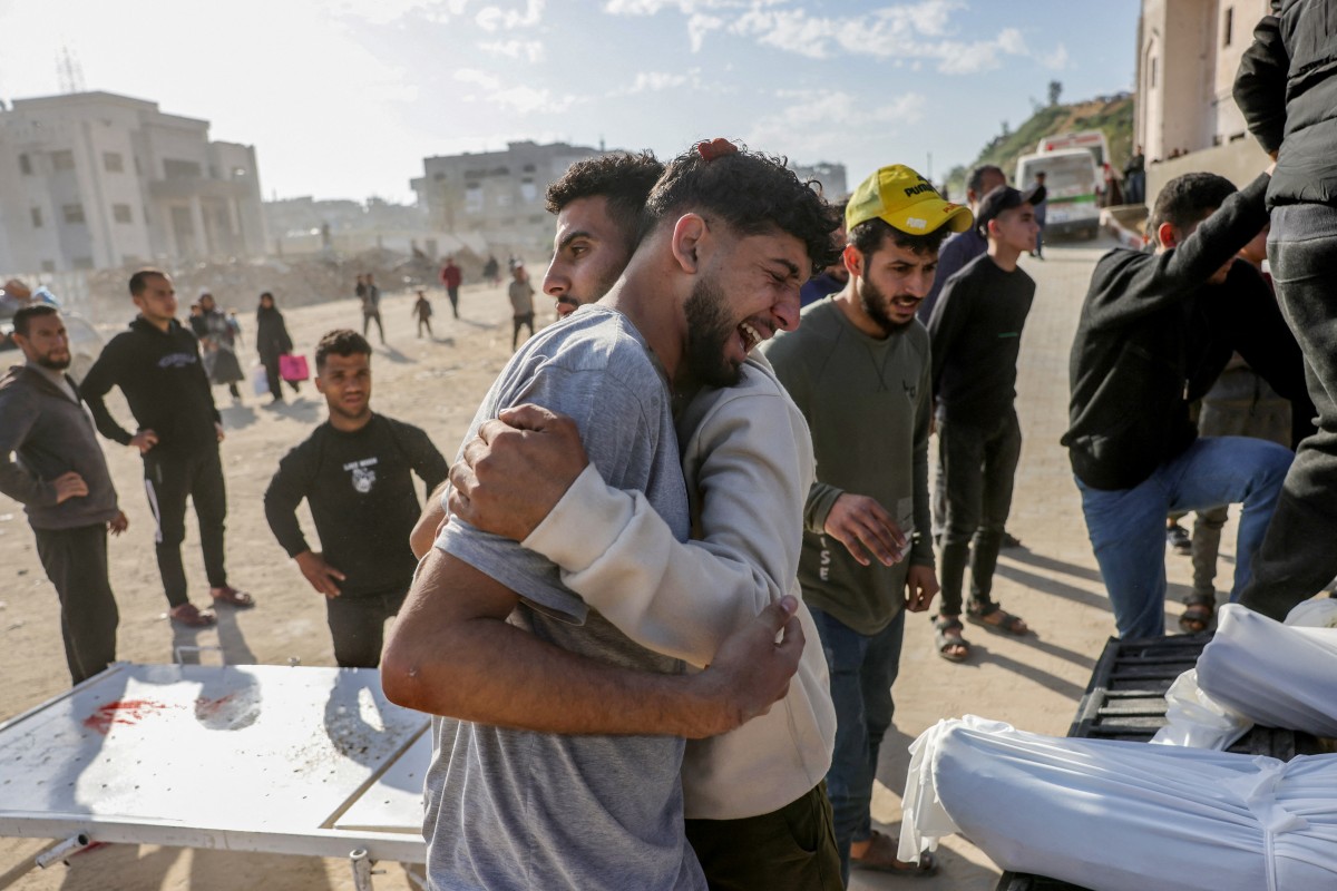 A Palestinian man is comforted as he weeps next to a truck carrying the bodies of the victims of Israeli overnight airstrikes before transporting them from the Indonesian Hospital in Beit Lahia in northern Gaza for burial. Photo / AFP