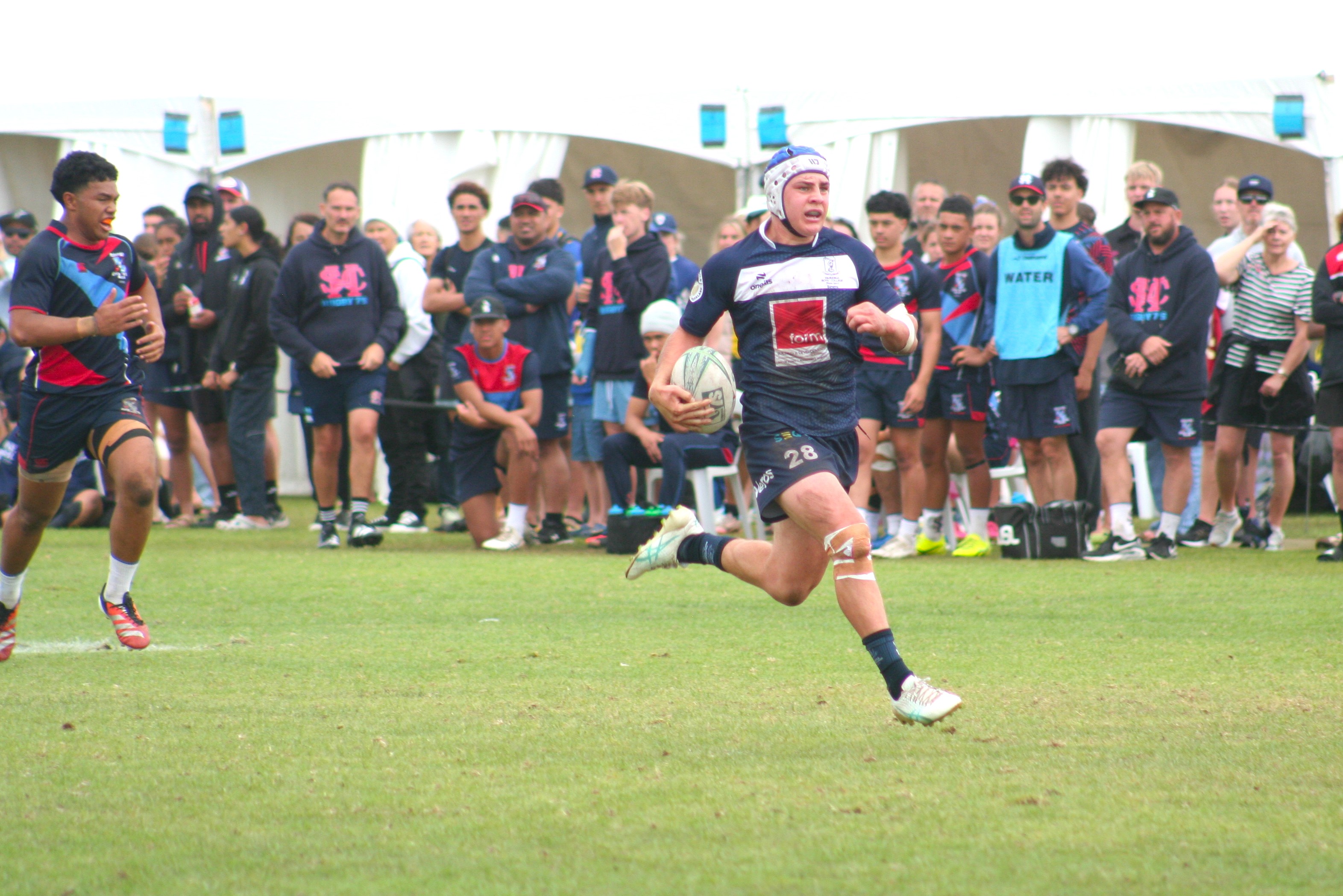 Jay McQuoid running in a second-half try for Tauranga in the Condor Sevens final against Sacred Heart.