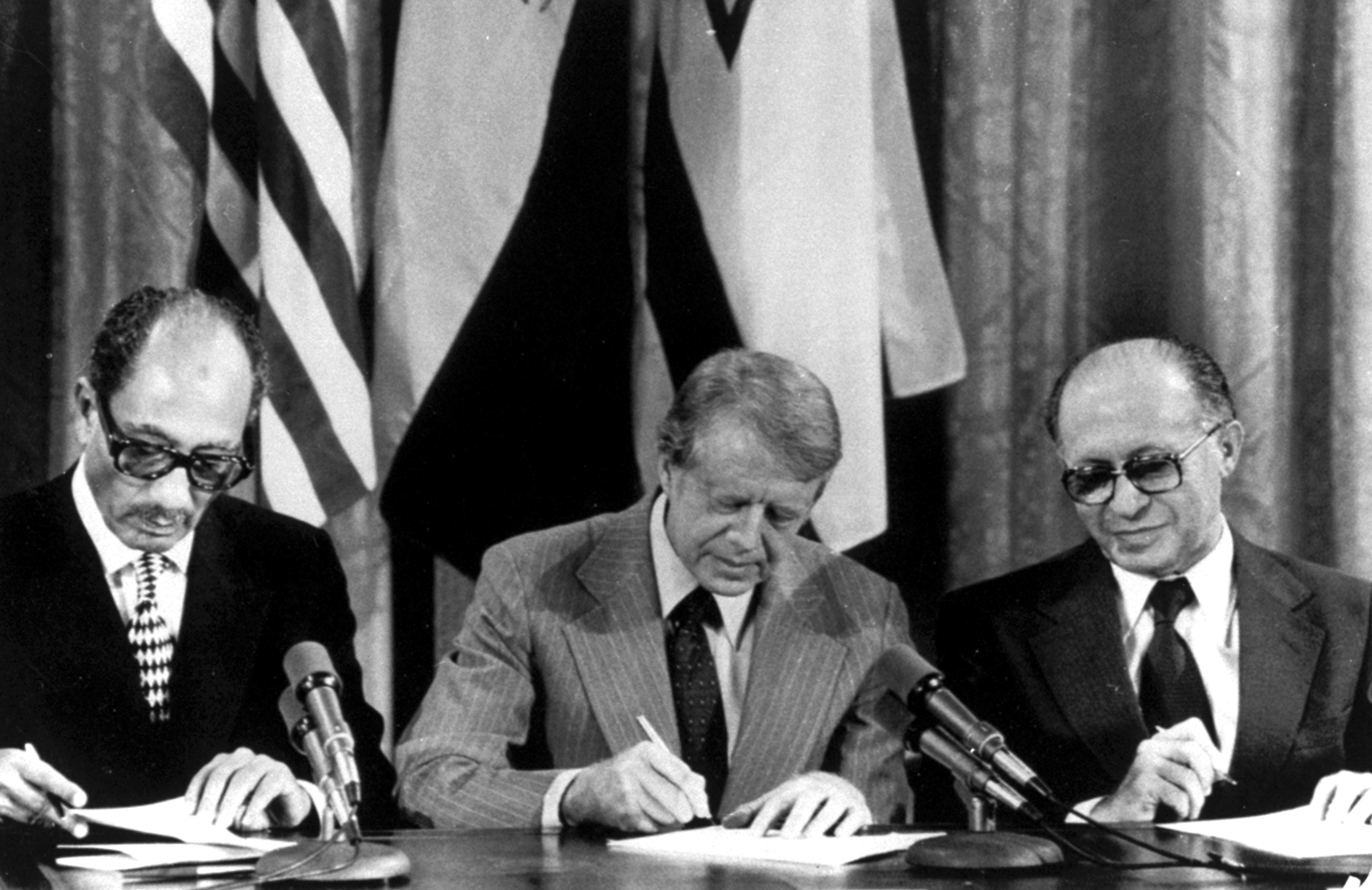 (From left): Egyptian President Anwar Sadat, US President Jimmy Carter and Israeli Prime Minister Menachem Begin sign one of two agreements forged at the Camp David Summit during a joint announcement at the White House on September 17, 1978. Photo / AP
