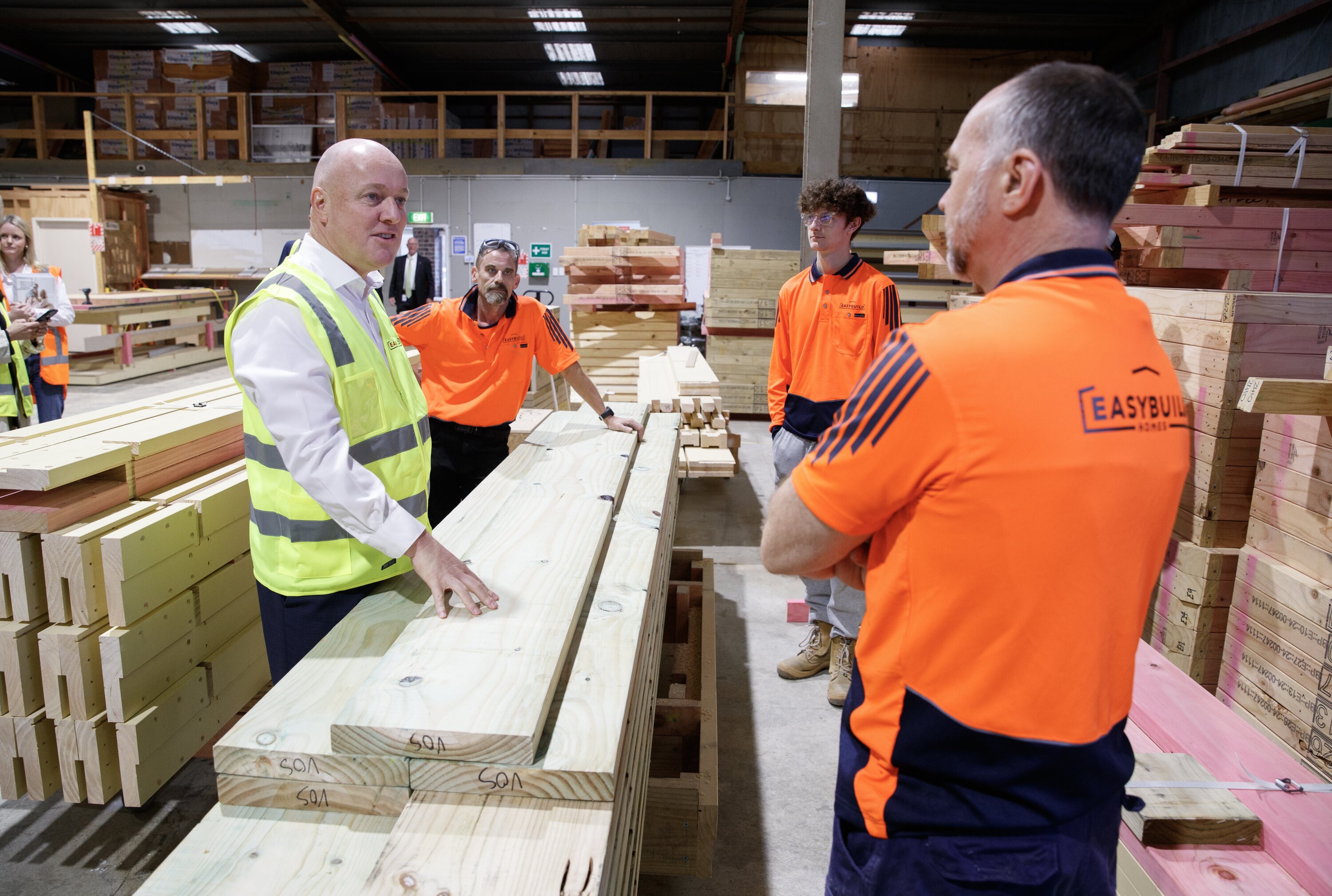 Prime Minister Christopher Luxon speaking with workers during his visit to Easy Build in Upper Hutt. Photo / Mark Mitchell