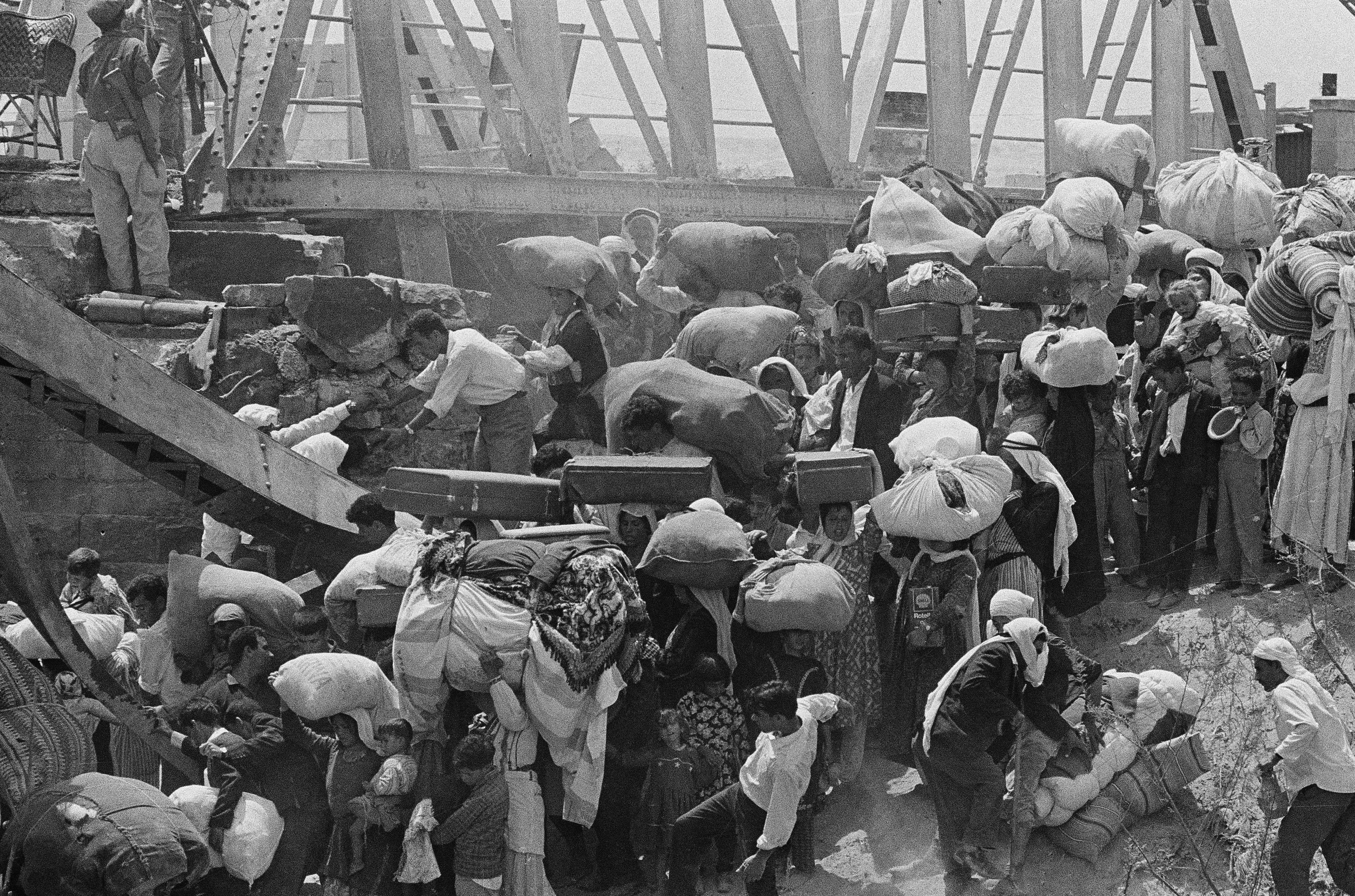 In this June 22, 1967 file photo, Palestinian refugees carry their belongings as they prepare to cross the wrecked Allenby Bridge over the Jordan River from the Israeli-occupied section of Jordan. Photo / AP