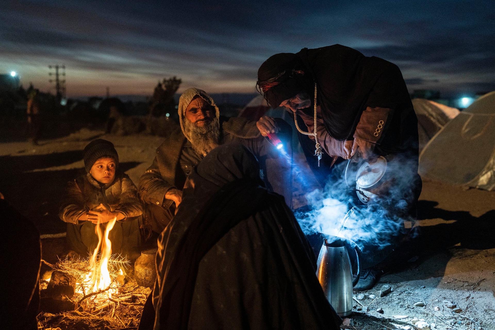 FILE - A family prepares tea outside the Directorate of Disaster office where they are camped, in Herat, Afghanistan. Photo / AP