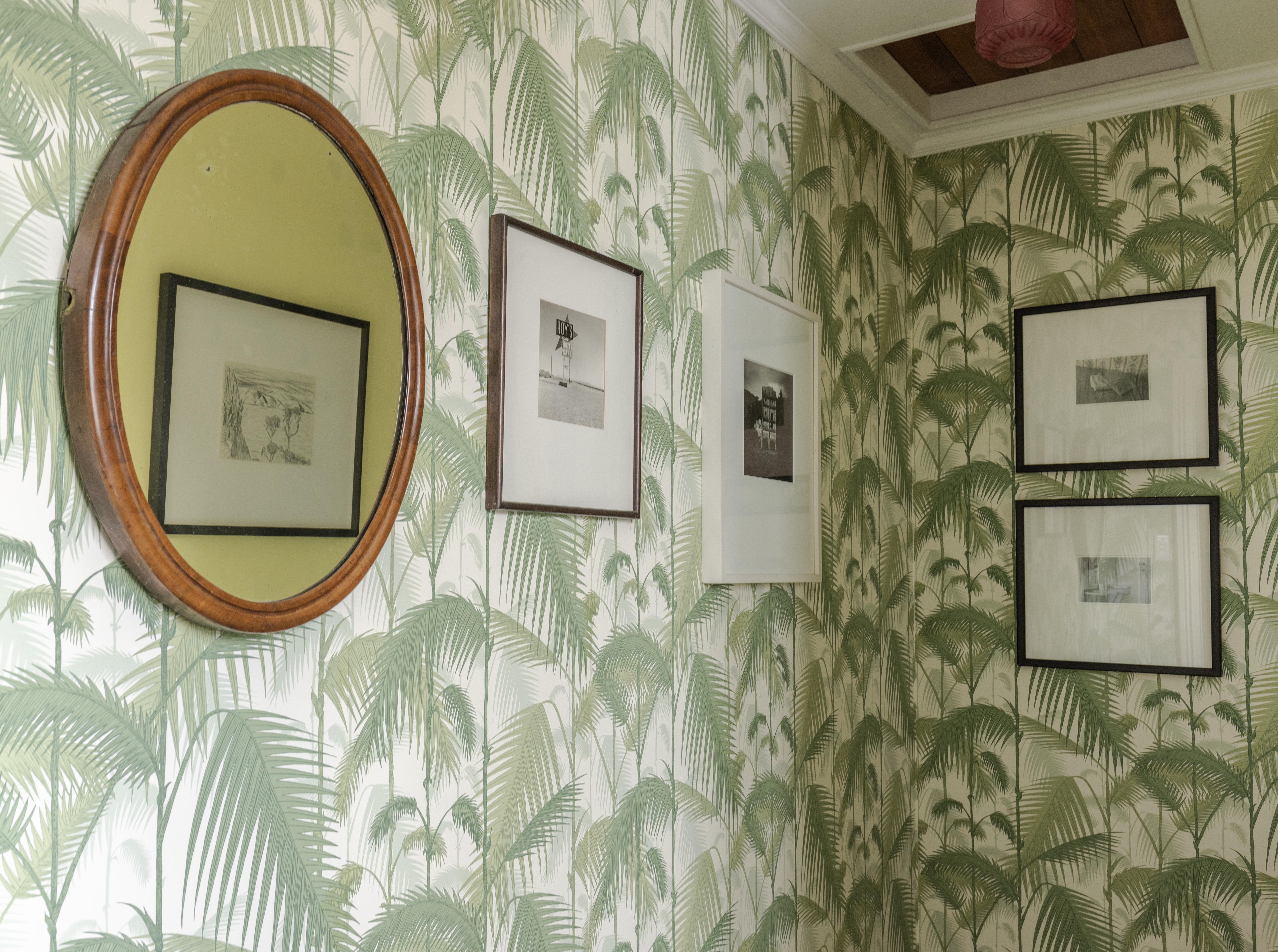 In the entrance to the bathroom, a drawing by Jeffrey Harris is reflected in the window. To the right, a photo by Andrew Rose, Peter Peryer and Gordon H. Brown look graphically bold on the patterned wallpaper. Photo / Ginny Fisher