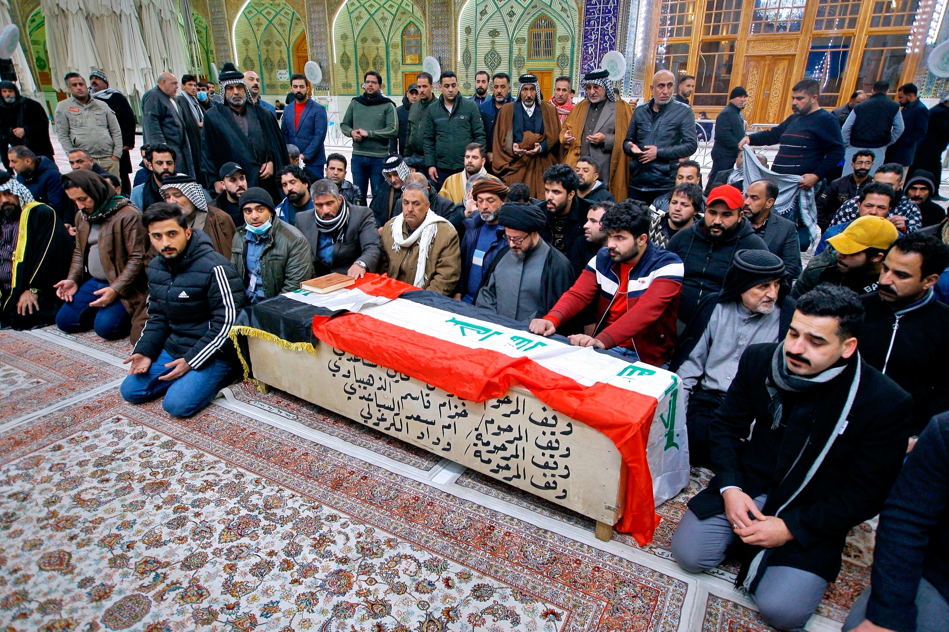 Mourners pray by the flag-draped coffin of a suicide bomb victim, Ahmed Reda during his funeral procession at the Imam Ali shrine in Najaf, Iraq. Photo / AP