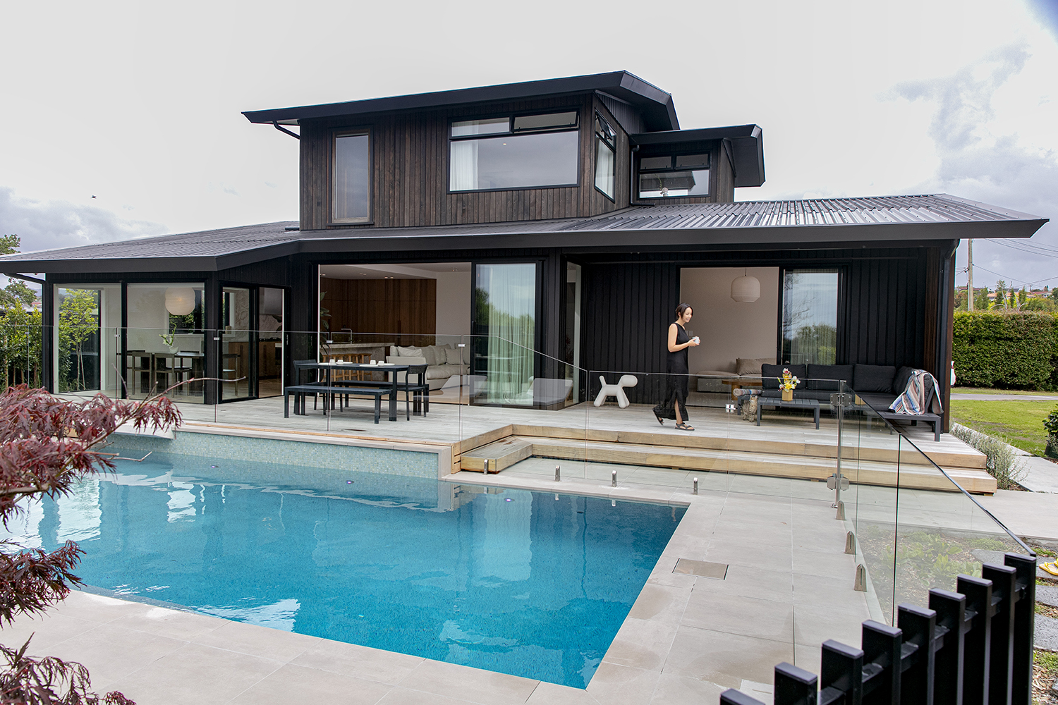When the couple throw open the expansive glass doors to the backyard and pool, the communal space more than doubles, with additional dining and lounge areas, as well as space poolside for relaxing and reclining. Photo / Babiche Martens