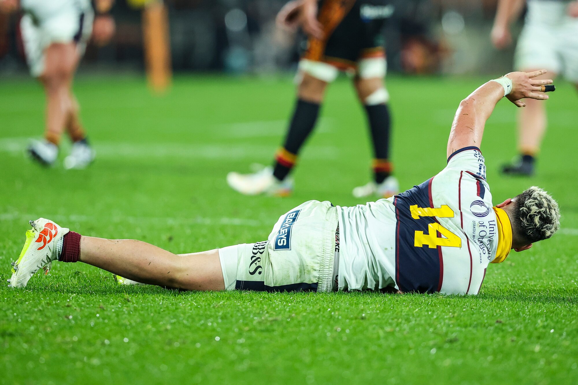 Highlanders winger Caleb Tangitau goes down injured in their clash against the Chiefs. Photo / Photosport