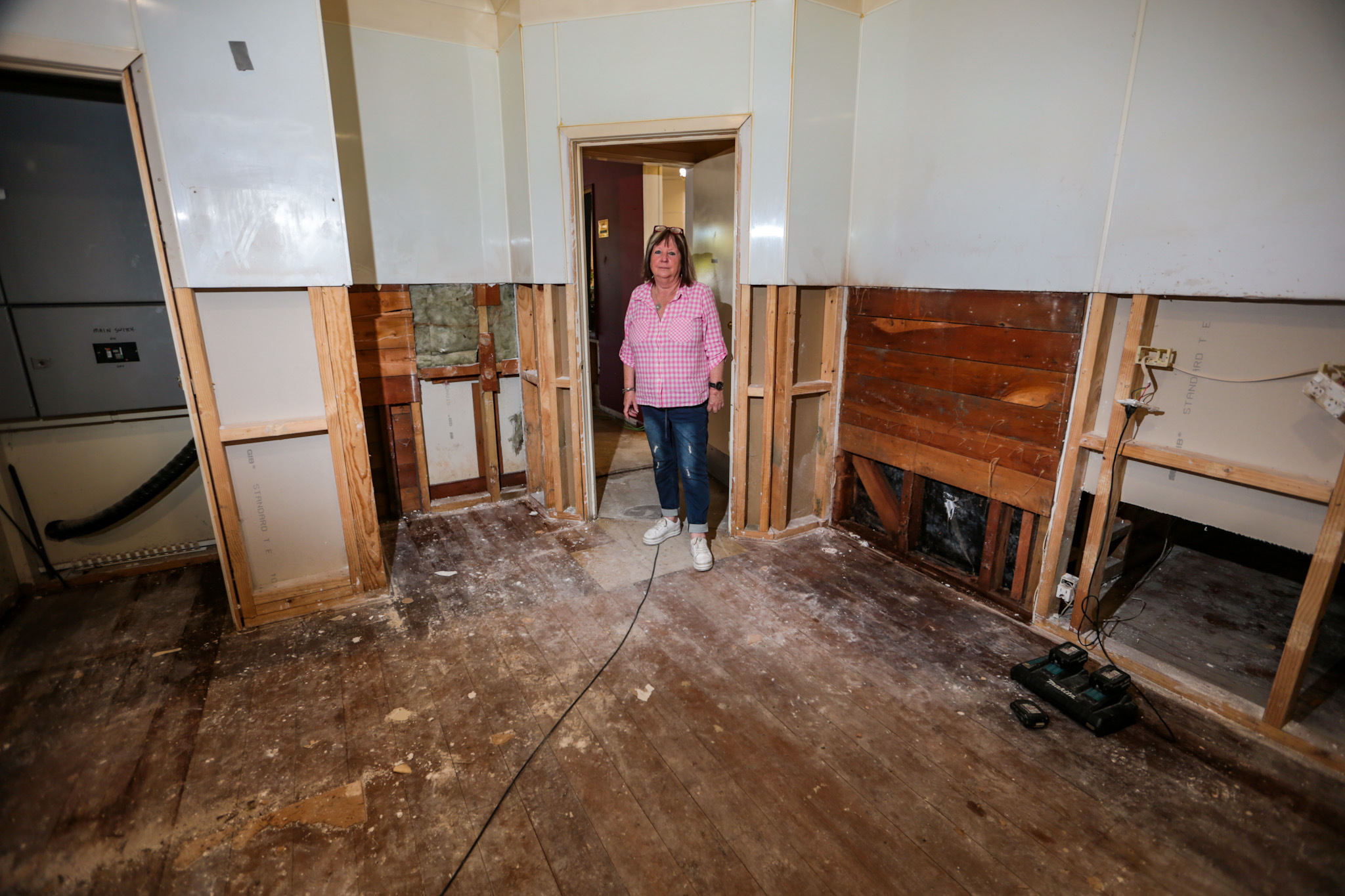 Mary Danielson shows an area inside the pub where damaged walls have been pulled up. Photo / Paul Taylor