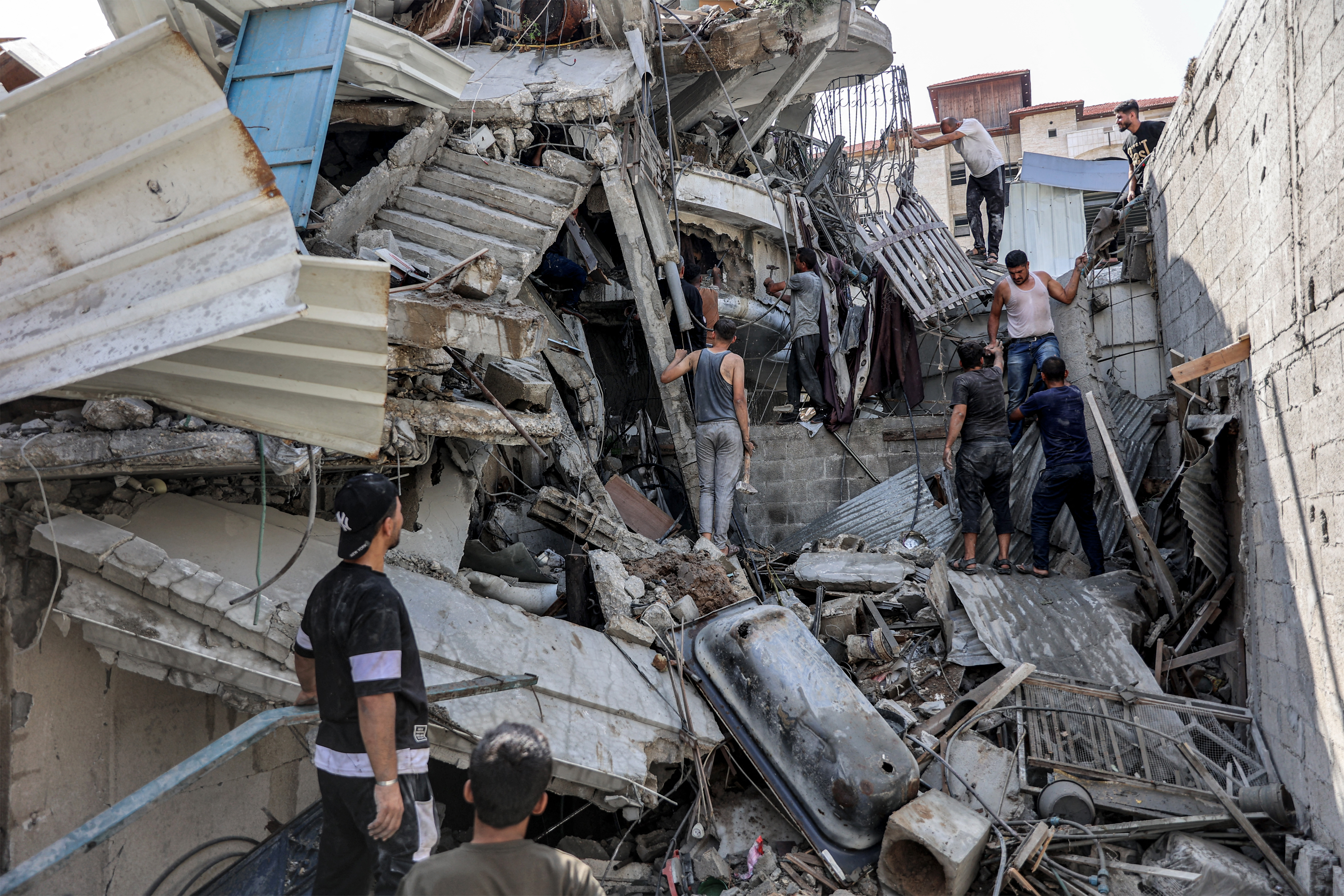 People gather outside a collapsed building as they attempt to extricate a man from underneath the rubble following Israeli bombardment in the Saftawi district in Jabalia in the northern Gaza Strip on October 15, 2024 amid the ongoing war in the Palestinian territory between Israel and Hamas. Photo / AFP