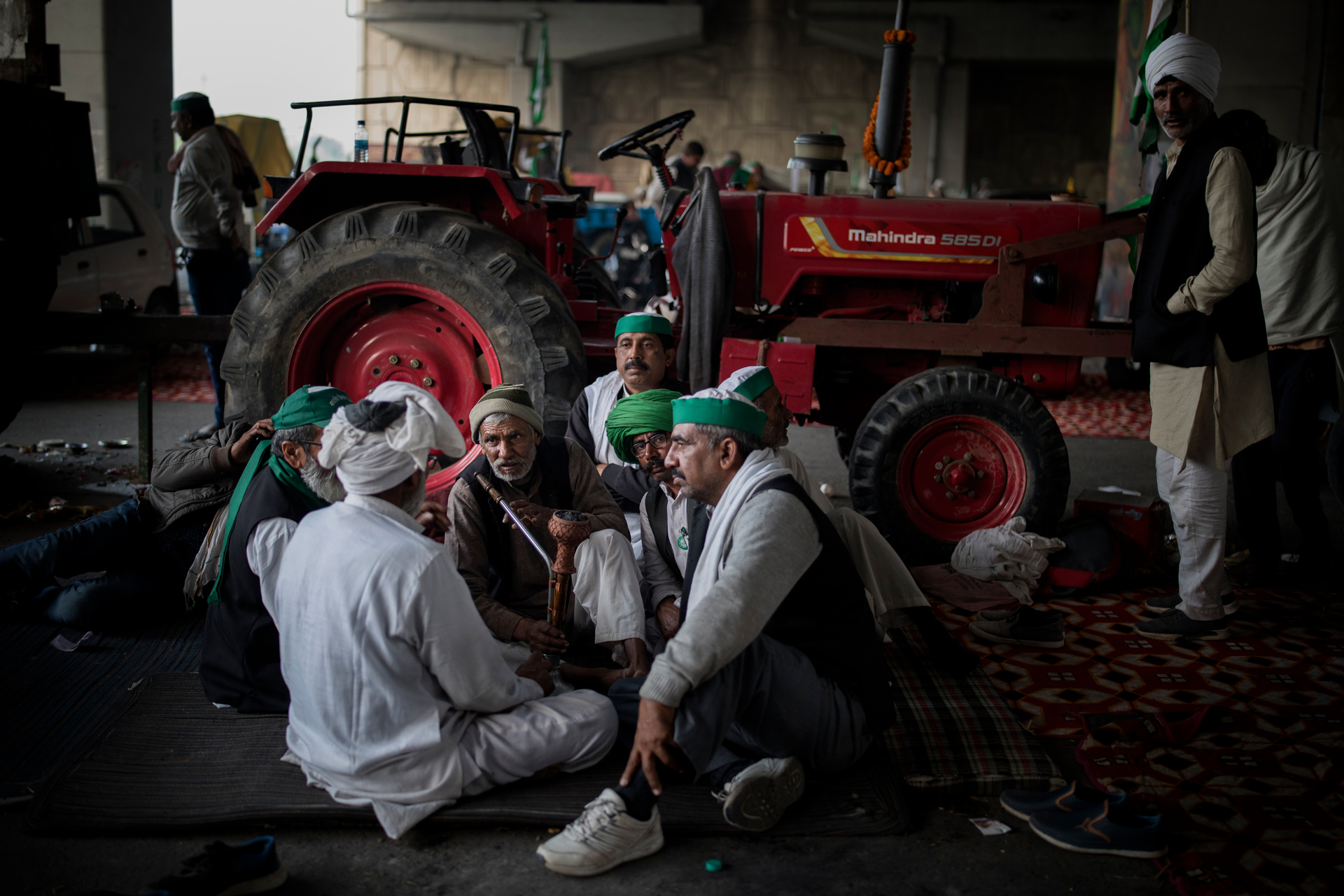 Farmers huddle together as they share a hookah while blocking a major highway during a protest against new farm laws at the Delhi-Uttar Pradesh state boarder. Photo / AP