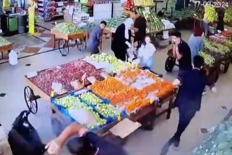 An image grab taken from a UGC video posted on social media on September 17 appears to show an explosion and a man falling to the floor (left) at an indoor vegetable market in Beirut, as hundreds of pagers used by Hezbollah members exploded across Lebanon. Photo / AFP / UGC 