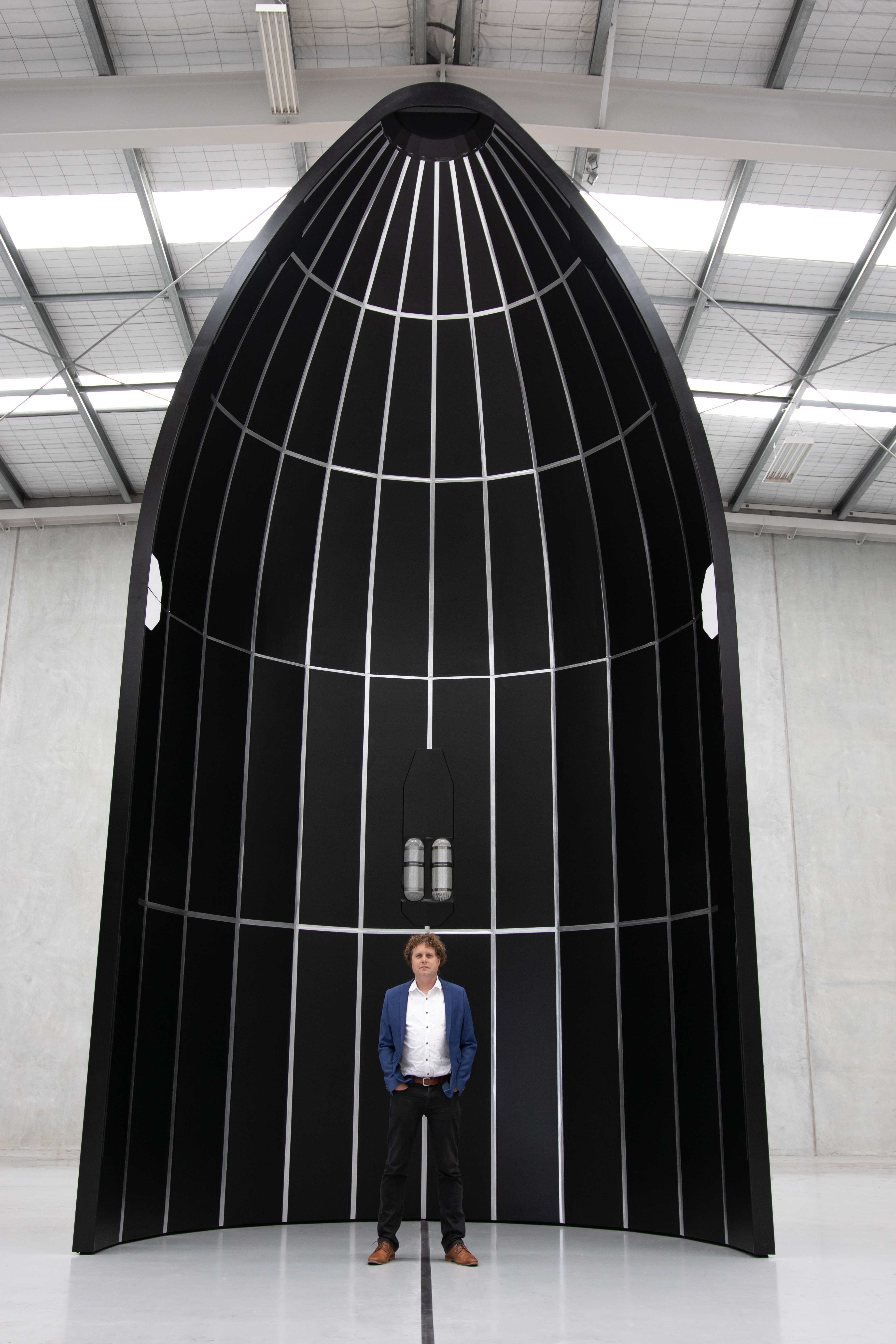 Rocket Lab founder and CEO Sir Peter Beck with a mockup of the fairing of his company's new rocket Neutron, currently under development. Photo / James Rattray