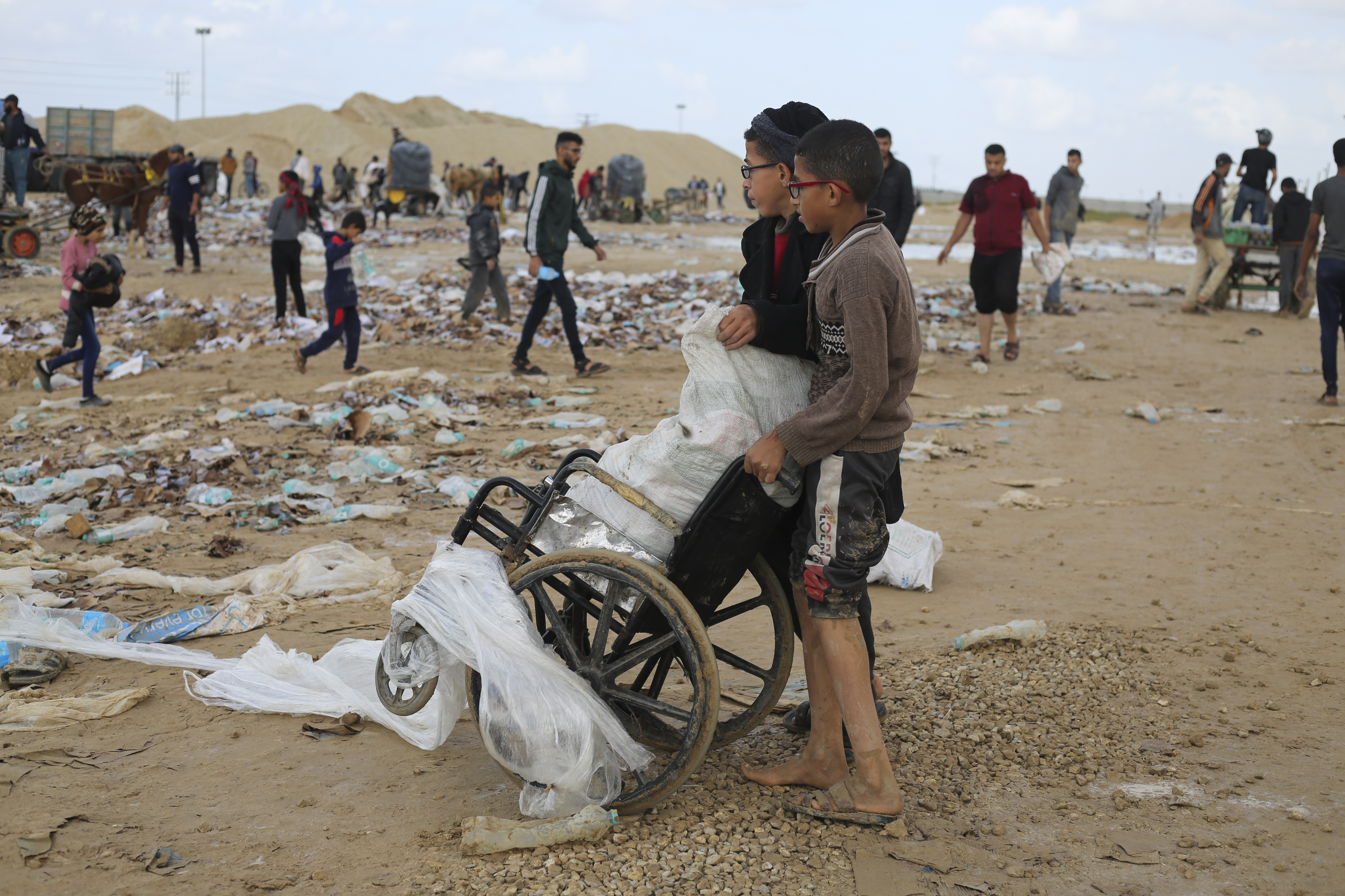 Palestinian boys transport water looted from the humanitarian aid trucks during the ongoing Israeli bombardment of the Gaza Strip at the border with Egypt in Rafah. Photo / AP